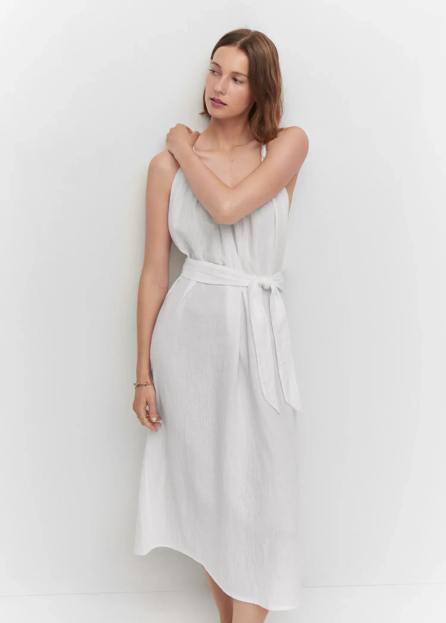 Mango Strap dress with belt. a woman in a white dress leaning against a wall. 