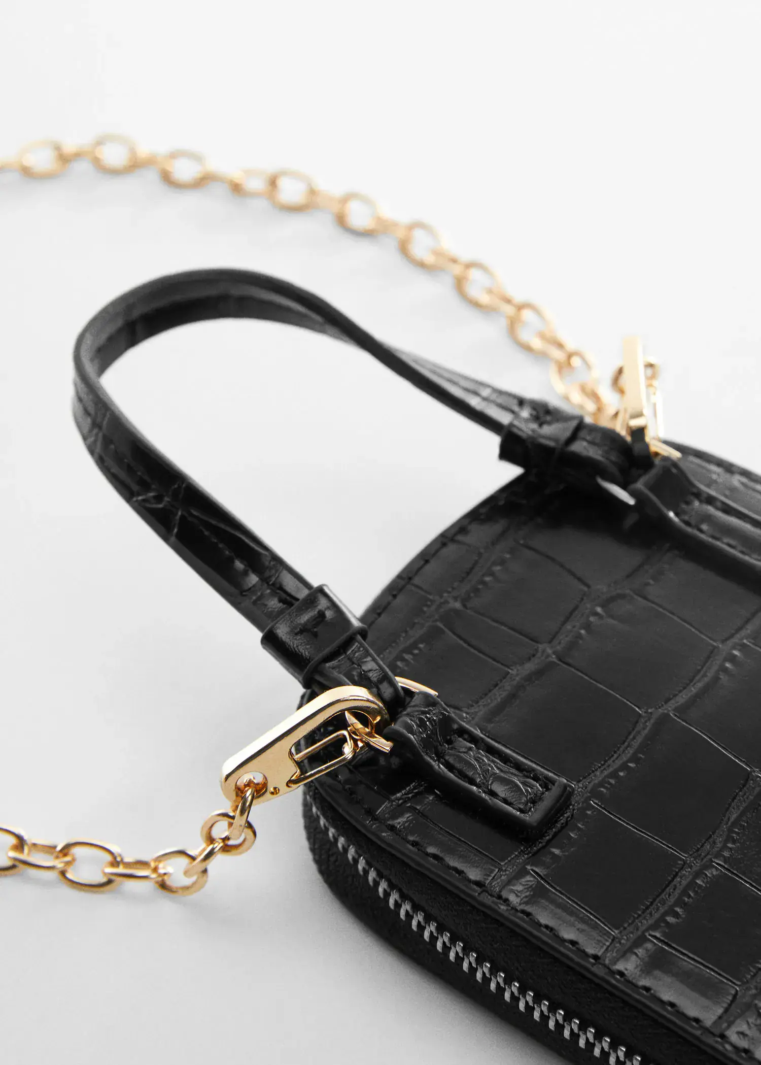 Mango Crocodile mobile case. a close-up of a black purse on a white surface. 
