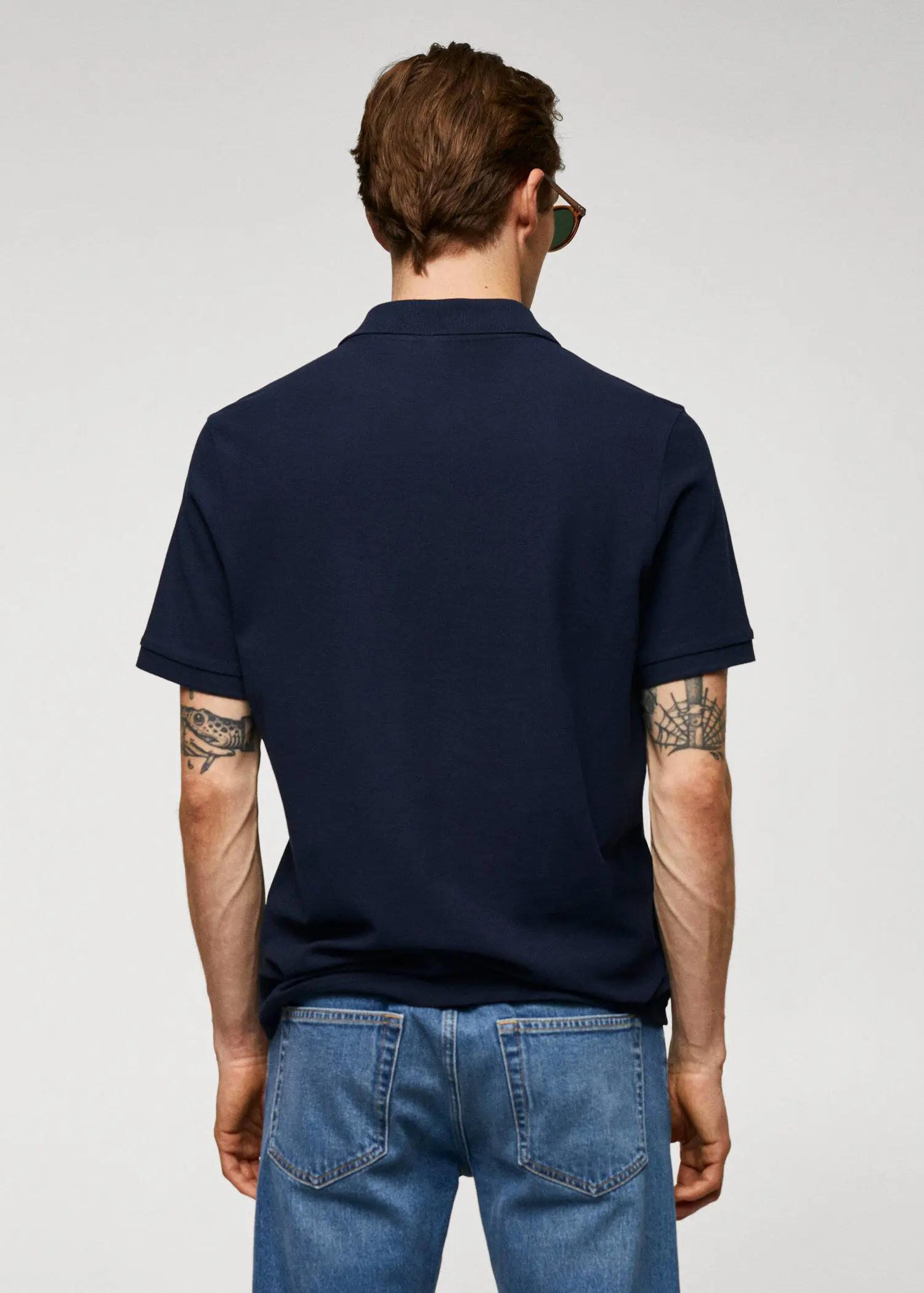 Mango 100% cotton pique polo shirt. a man with tattoos on his arms wearing jeans. 