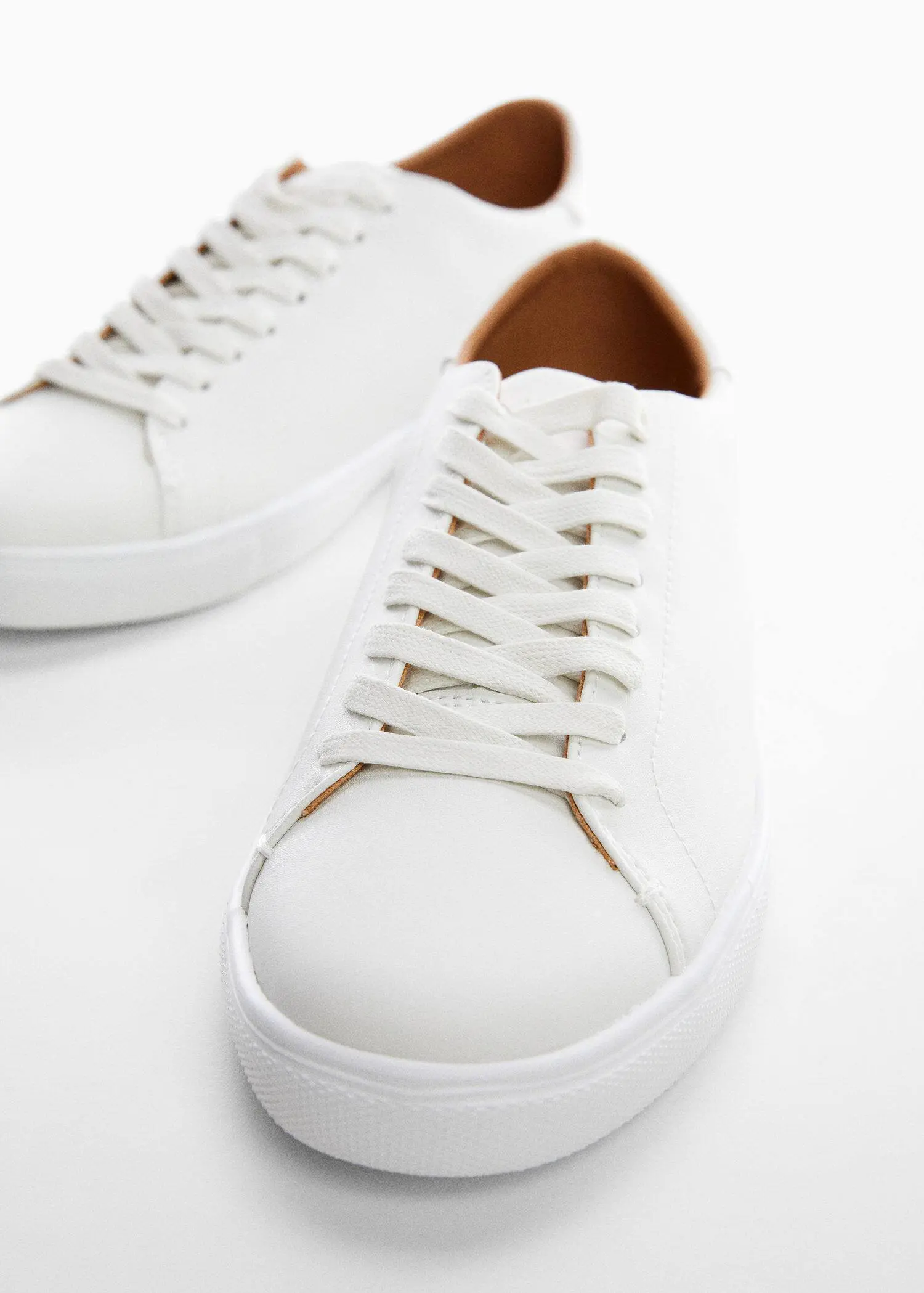 Mango Monocoloured leather sneakers. a close up of a pair of white shoes 