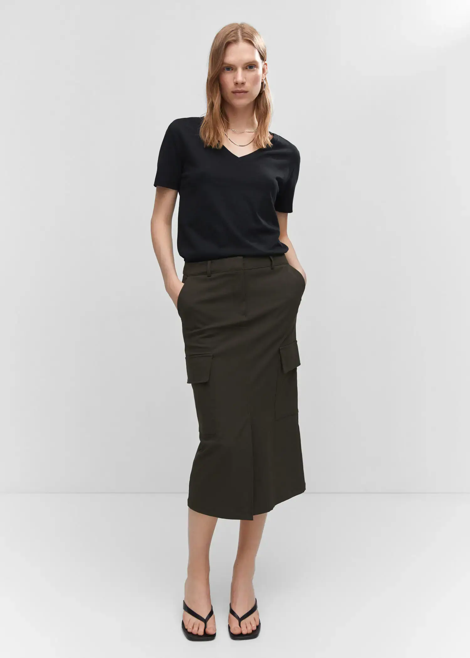 Mango V-neck cotton T-shirt. a woman wearing a black shirt and a black skirt. 