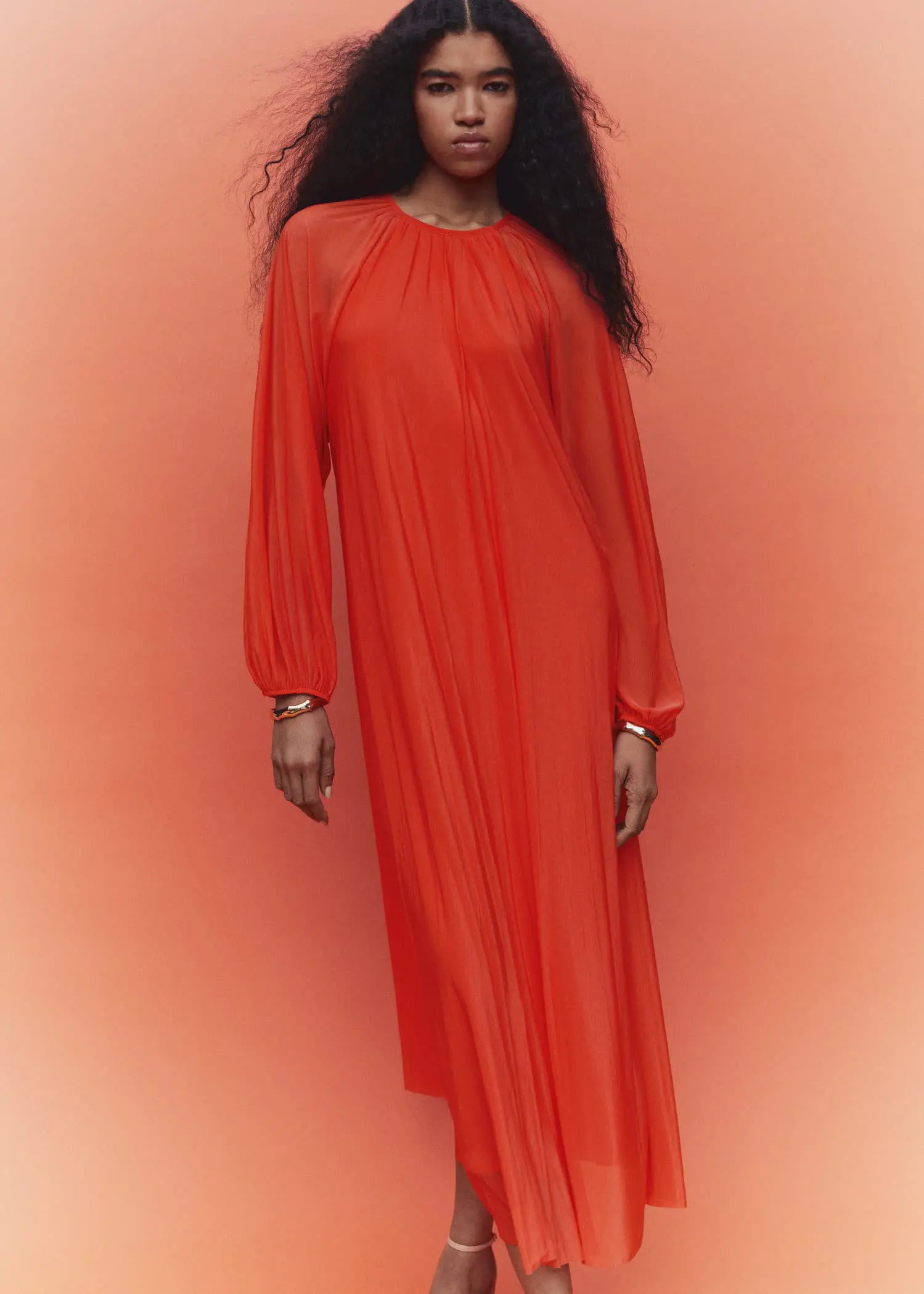 Mango Puffed sleeves dress. a woman in a red dress standing in front of a pink background. 