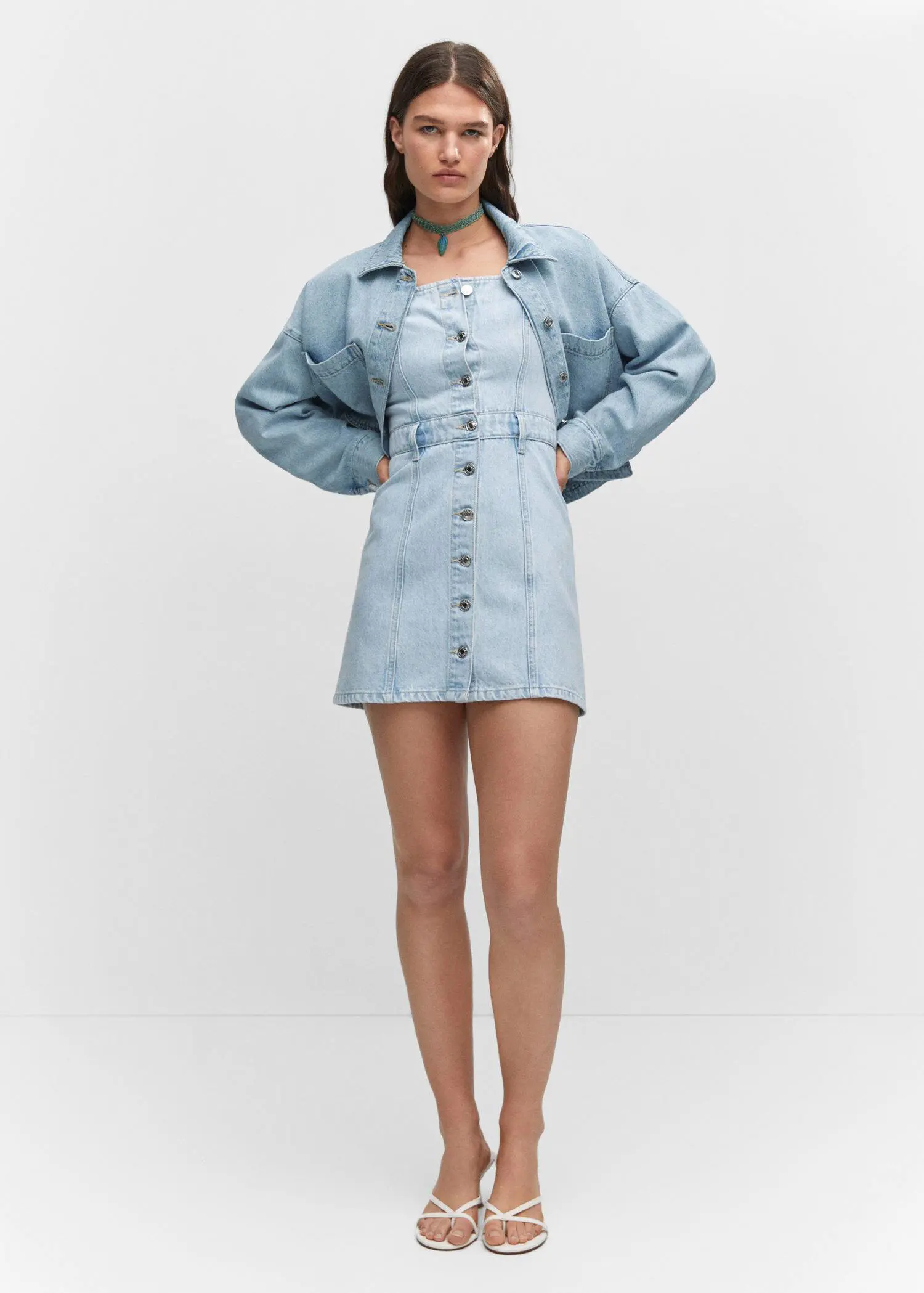 Mango Pocket denim overshirt. a person standing in front of a white wall 