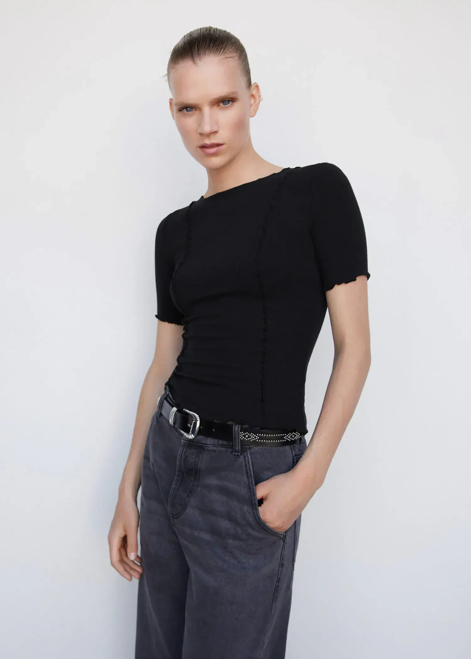 Mango Decorative seam T-shirt. a woman wearing a black shirt and a black belt. 