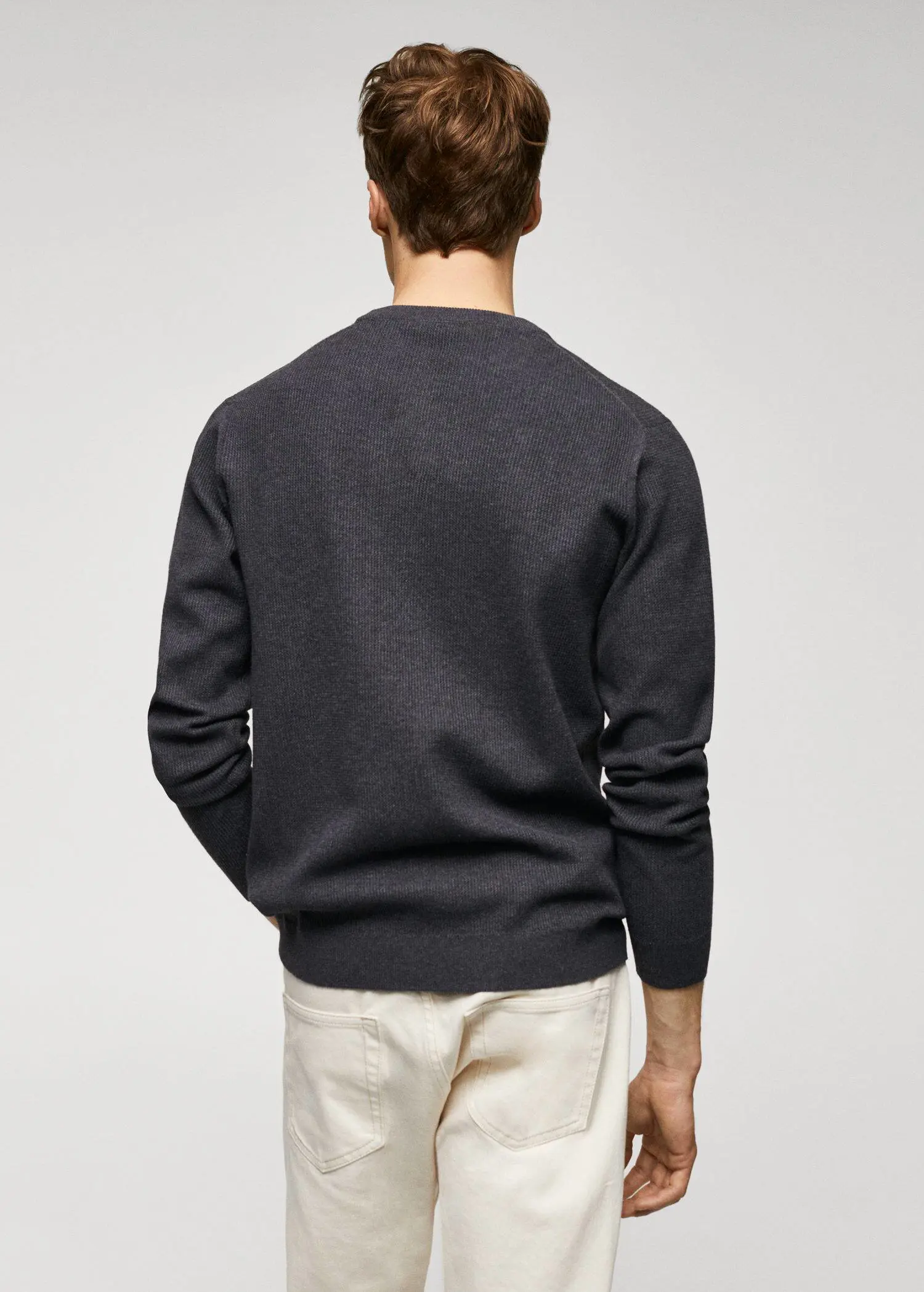 Mango Structured cotton sweater. a man wearing a black sweater and white pants. 