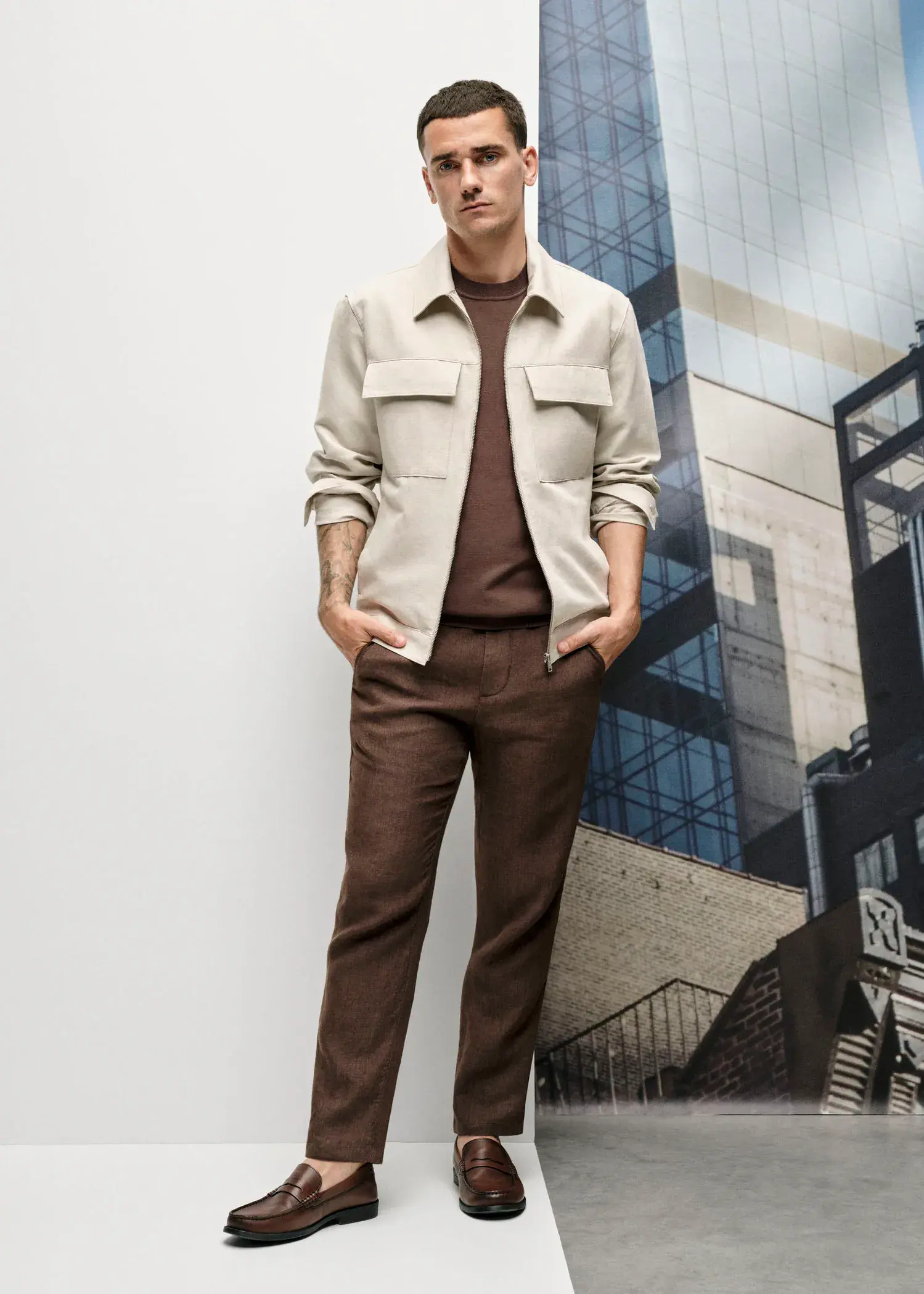 Mango Slim-fit 100% linen trousers. a man standing in front of a building with his hands in his pockets. 