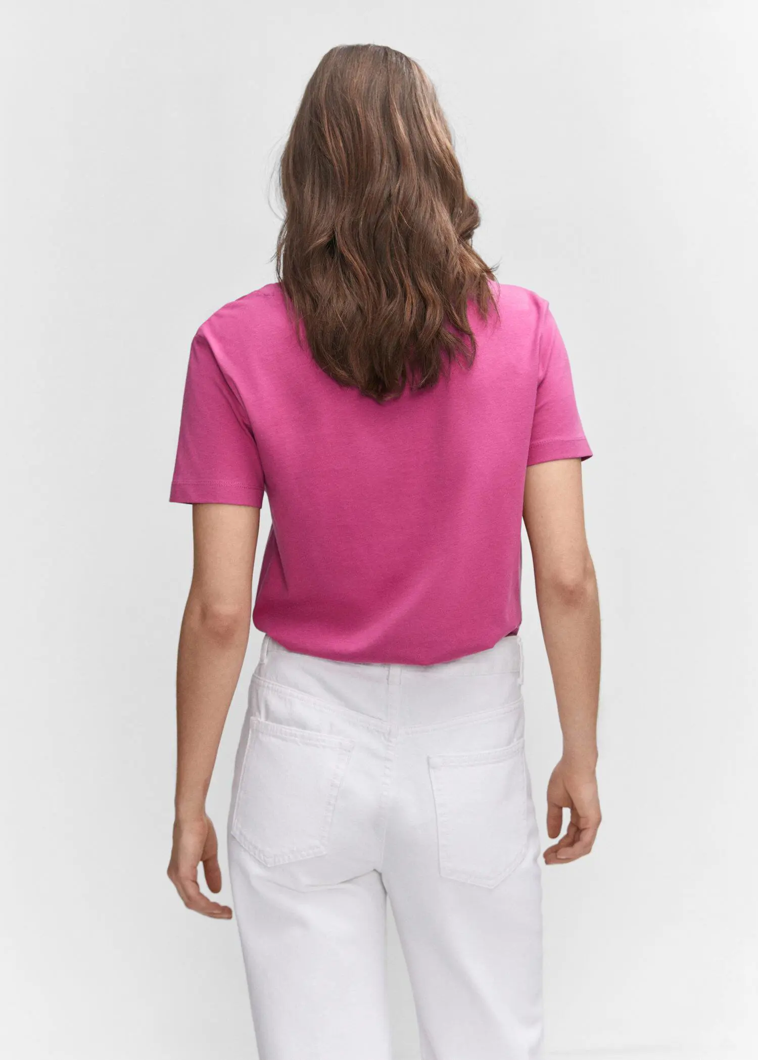 Mango V-neck cotton T-shirt. a woman wearing a pink shirt and white pants. 