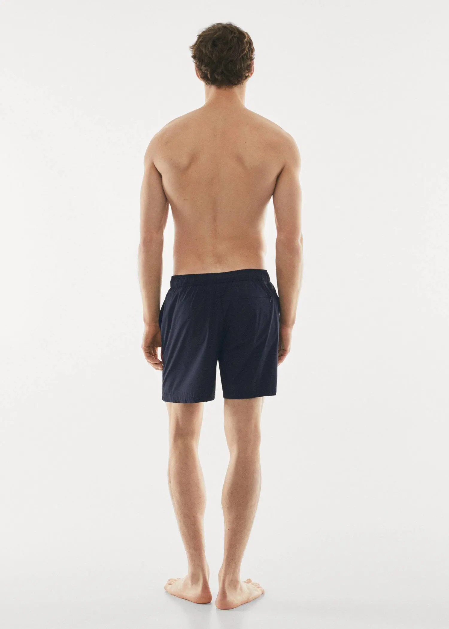 Mango Cord plain swimming trunks. a man standing with his back to the camera. 