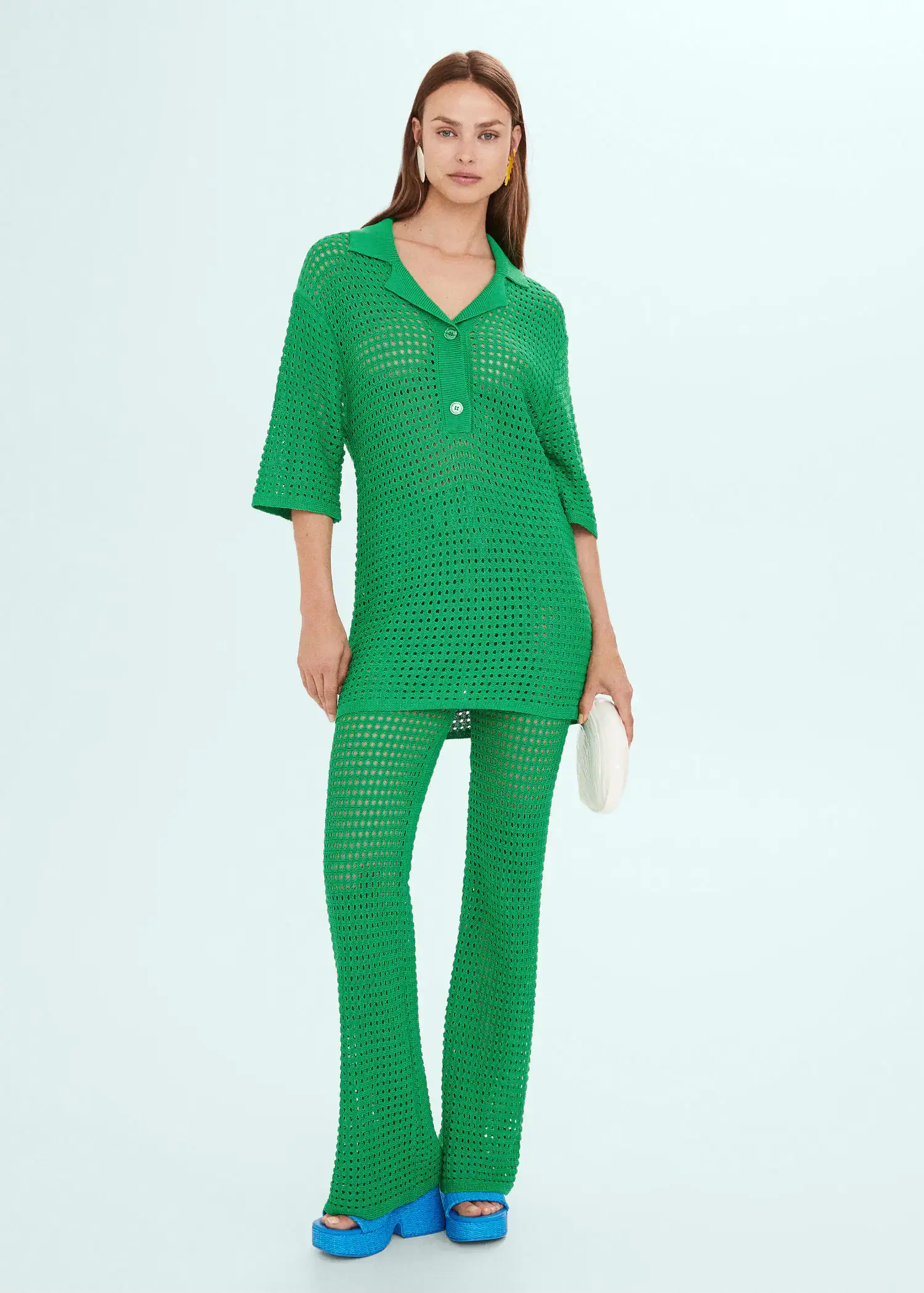 Mango Oversized openwork knitted polo shirt. a woman in a green outfit is holding a purse. 