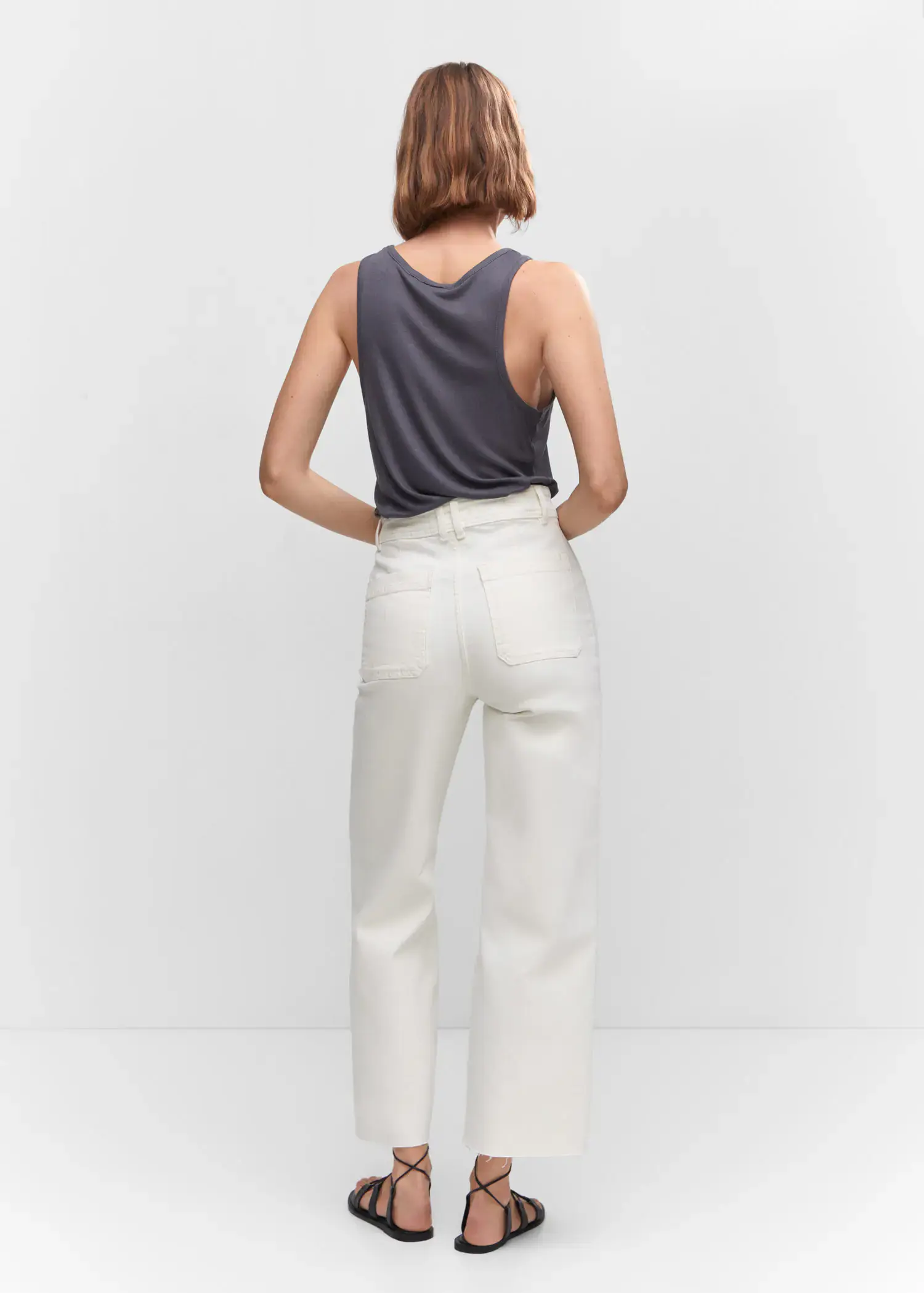 Mango Jeans culotte high waist. a woman wearing white pants and a gray tank top. 
