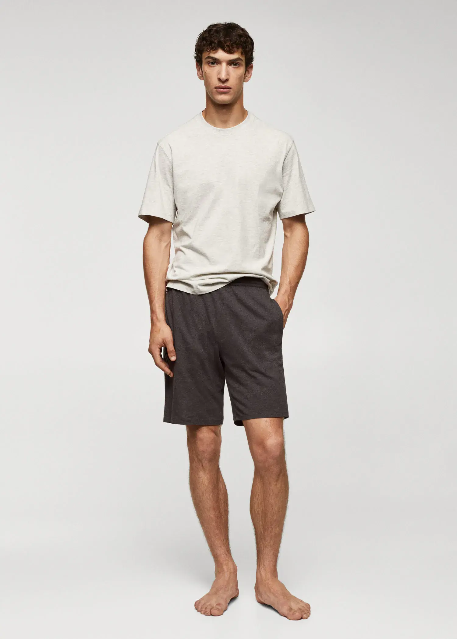 Mango Cotton pyjama shorts pack. a young man in a white t-shirt and black shorts. 