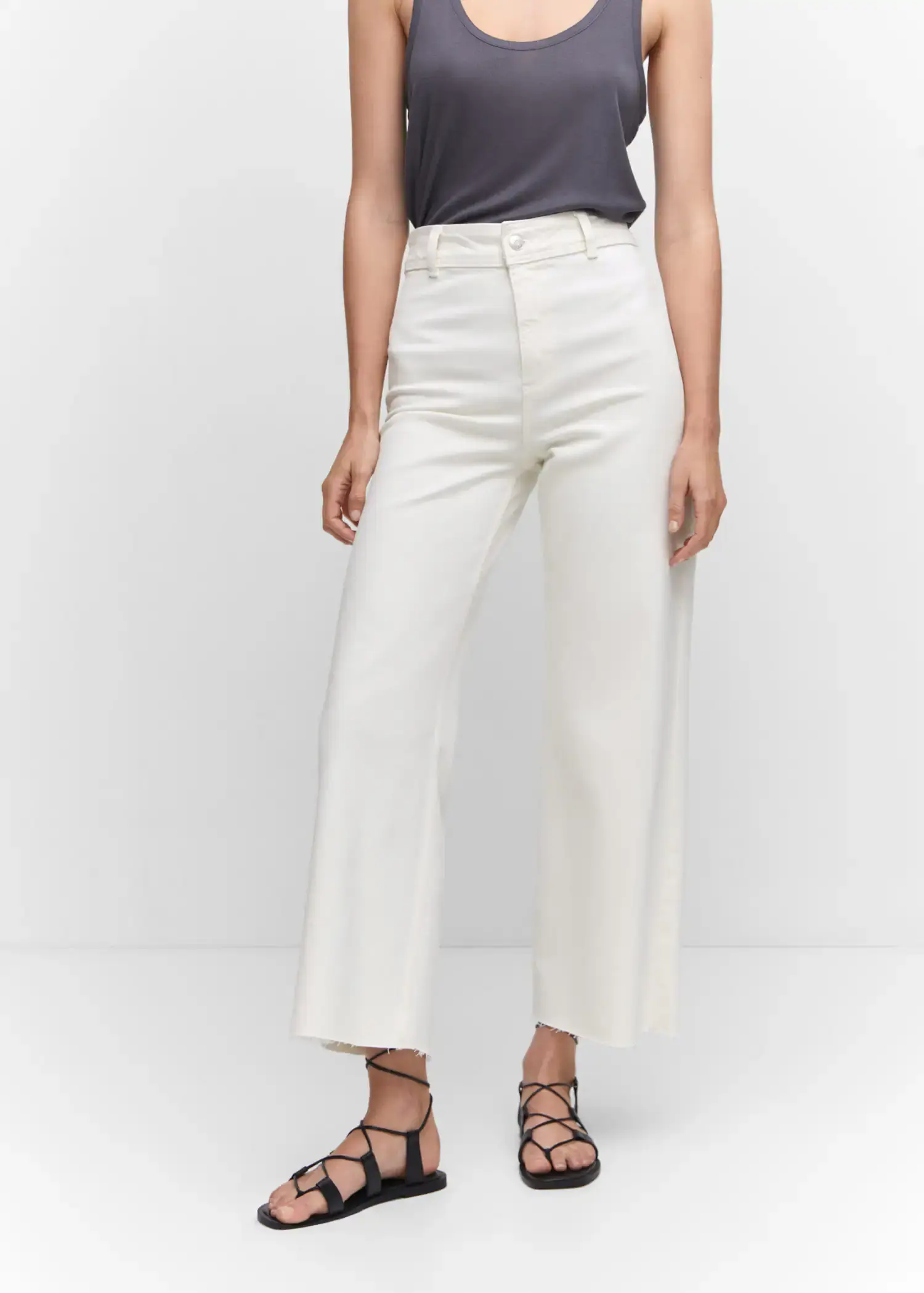 Mango Jeans culotte high waist. a woman in white pants and a black top. 