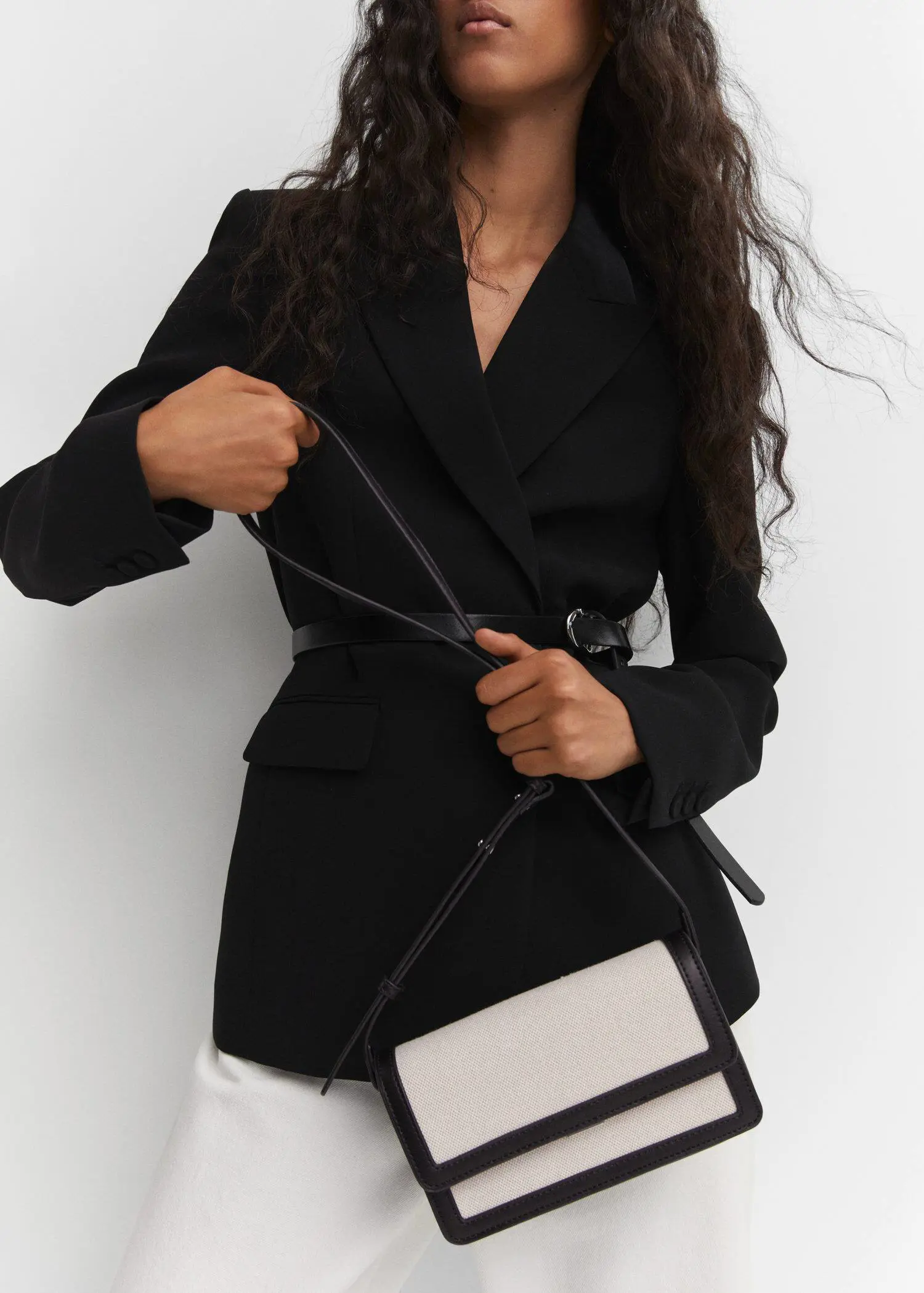 Mango Textured bag with flap. a woman in a black jacket holding a bag. 