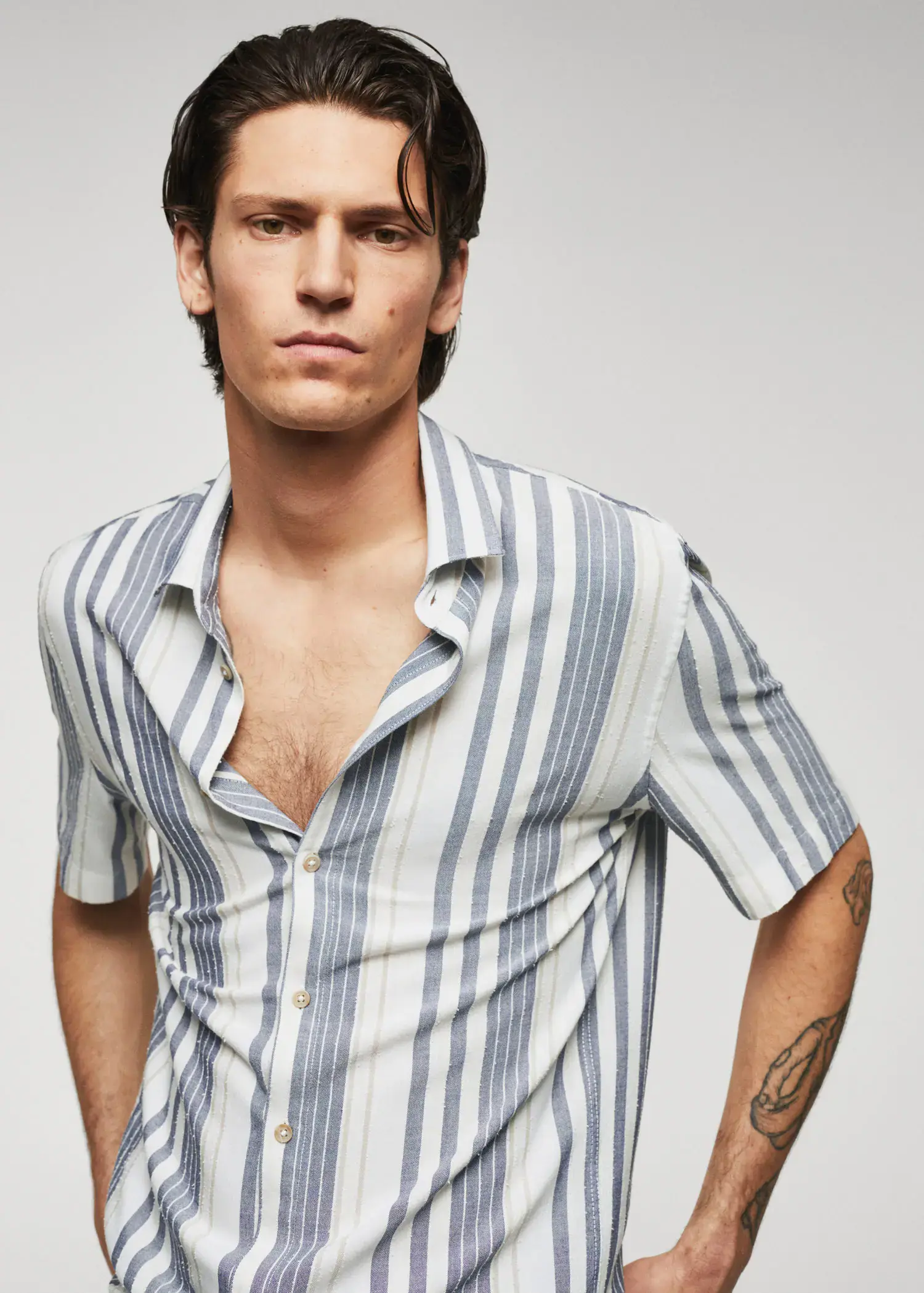 Mango Striped slim-fit shirt. a young man with a tattoo on his arm. 