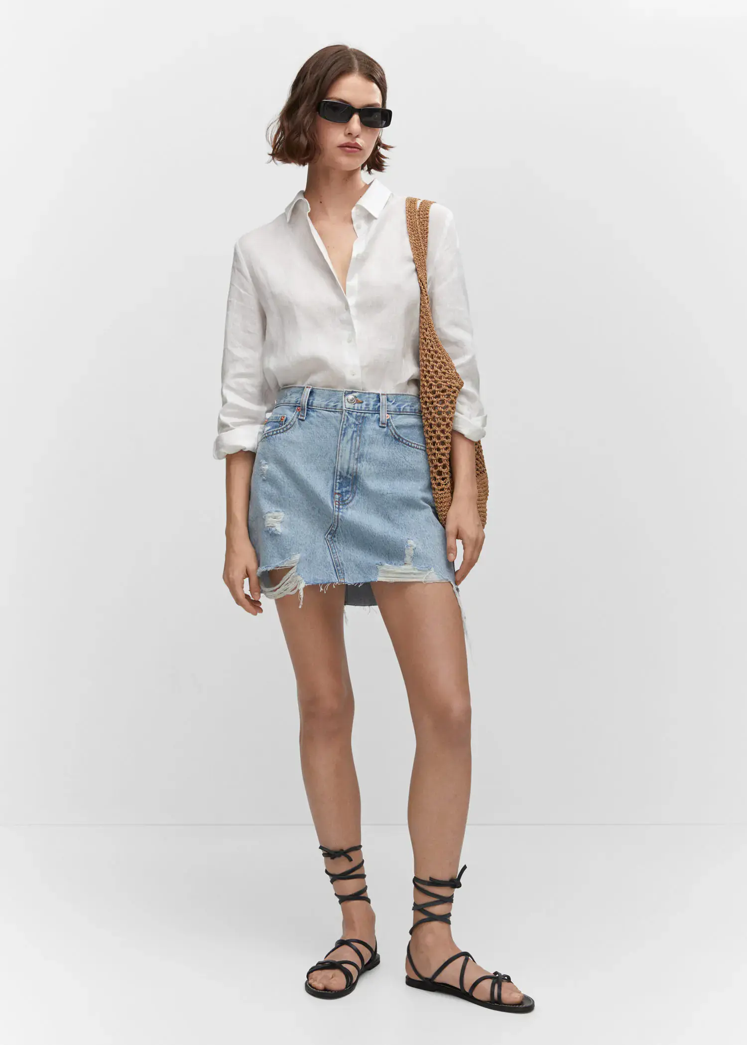 Mango Denim mini-skirt. a woman in a white shirt and a jean skirt. 