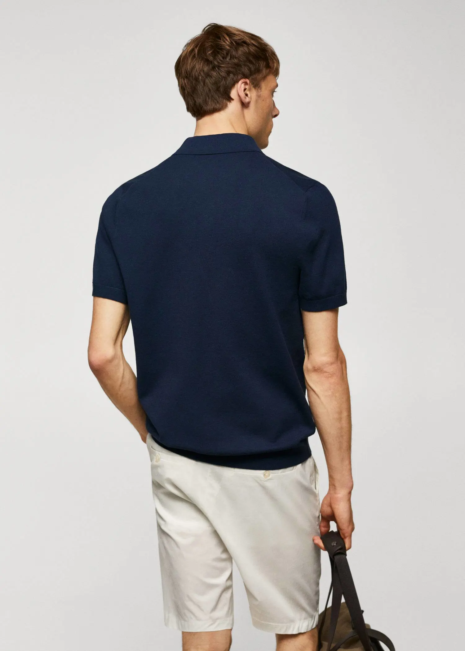 Mango Fine-knit polo shirt. a man in a blue shirt is holding a phone. 