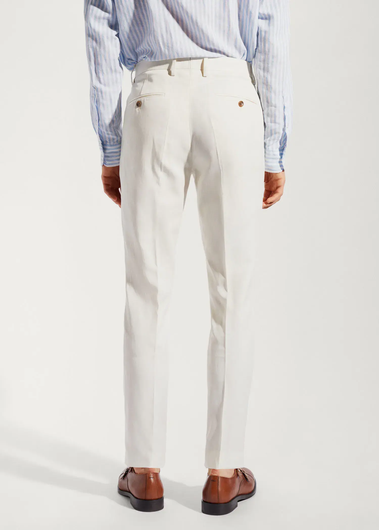 Mango 100% linen suit trousers. a man wearing white pants and a striped shirt. 