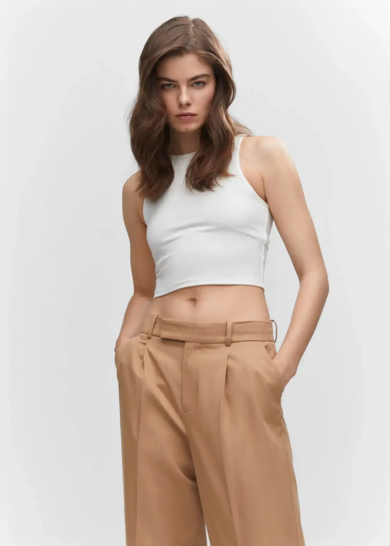 Mango Crop top halter neck. a woman in a white crop top and brown pants. 