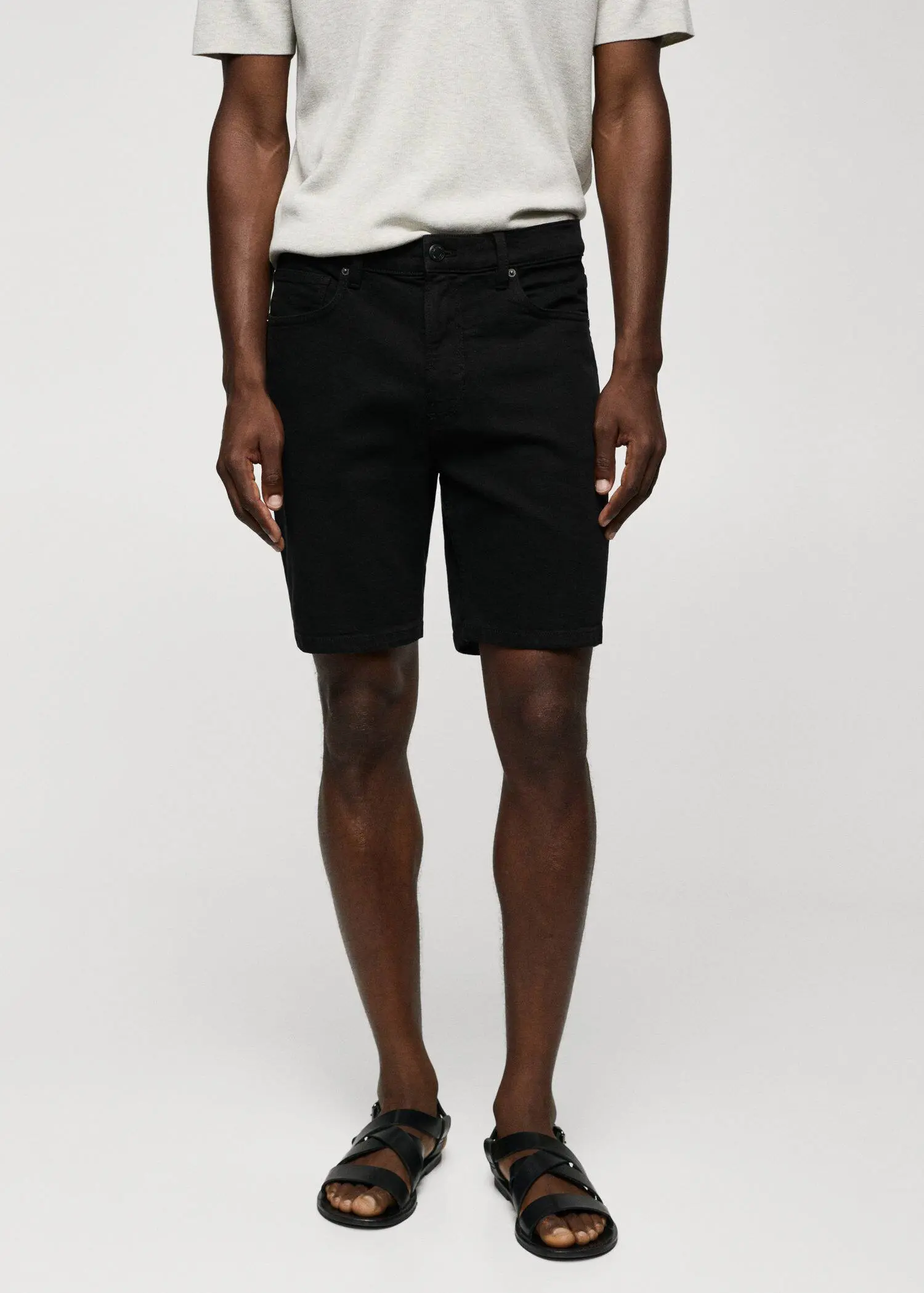 Mango Regular-fit denim bermuda shorts. a man in black shorts and a white t-shirt. 