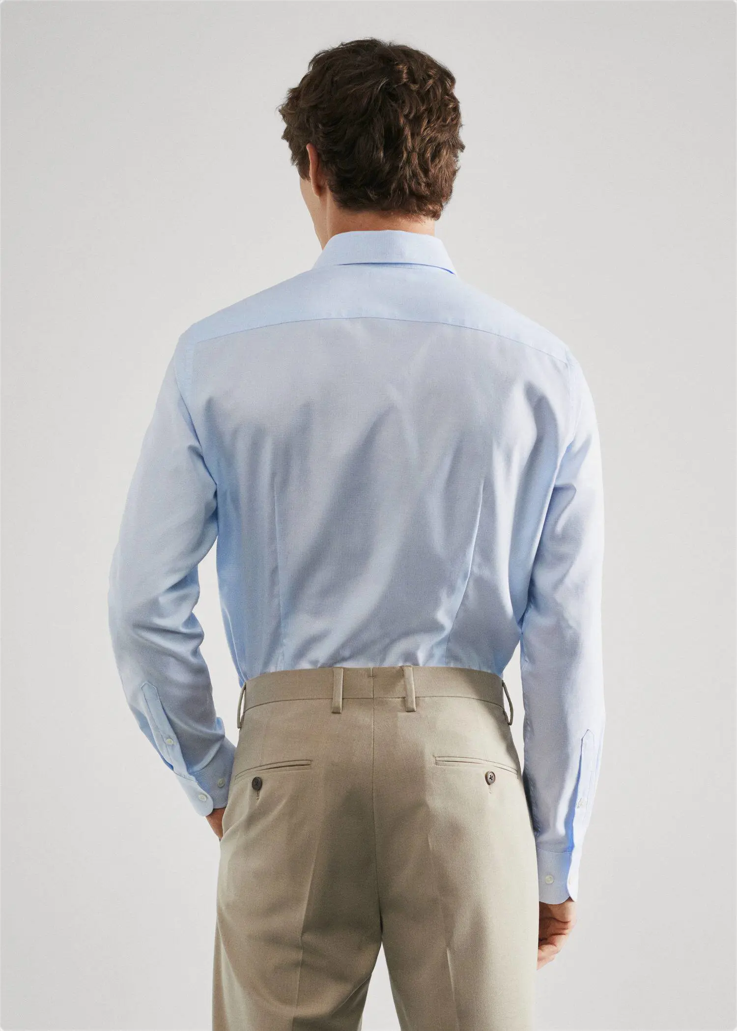 Mango Slim fit structured suit shirt. a man in a blue shirt and tan pants. 