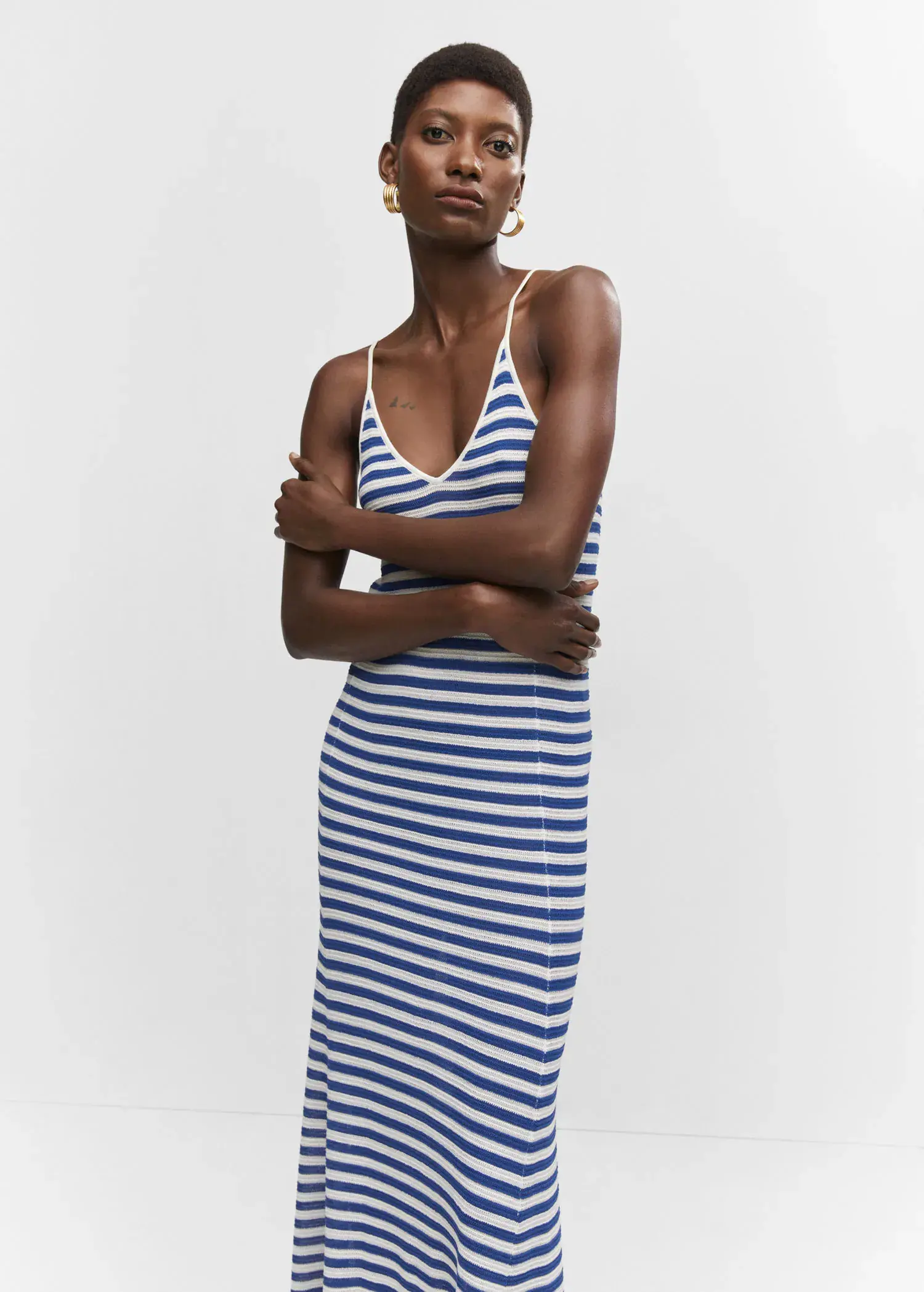 Mango Striped jersey dress. a woman standing with her arms crossed wearing a striped dress. 