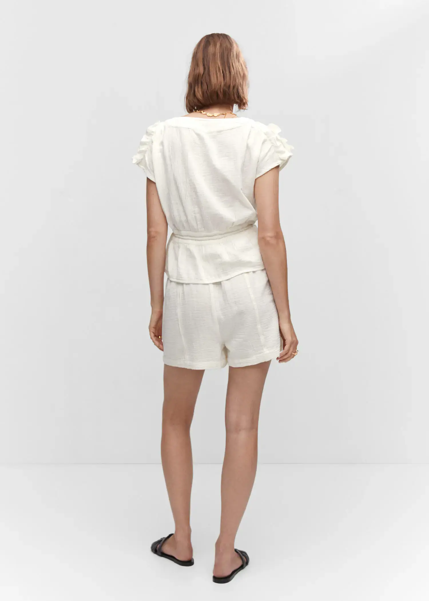Mango Bow textured blouse. a woman wearing a white outfit standing in front of a wall. 