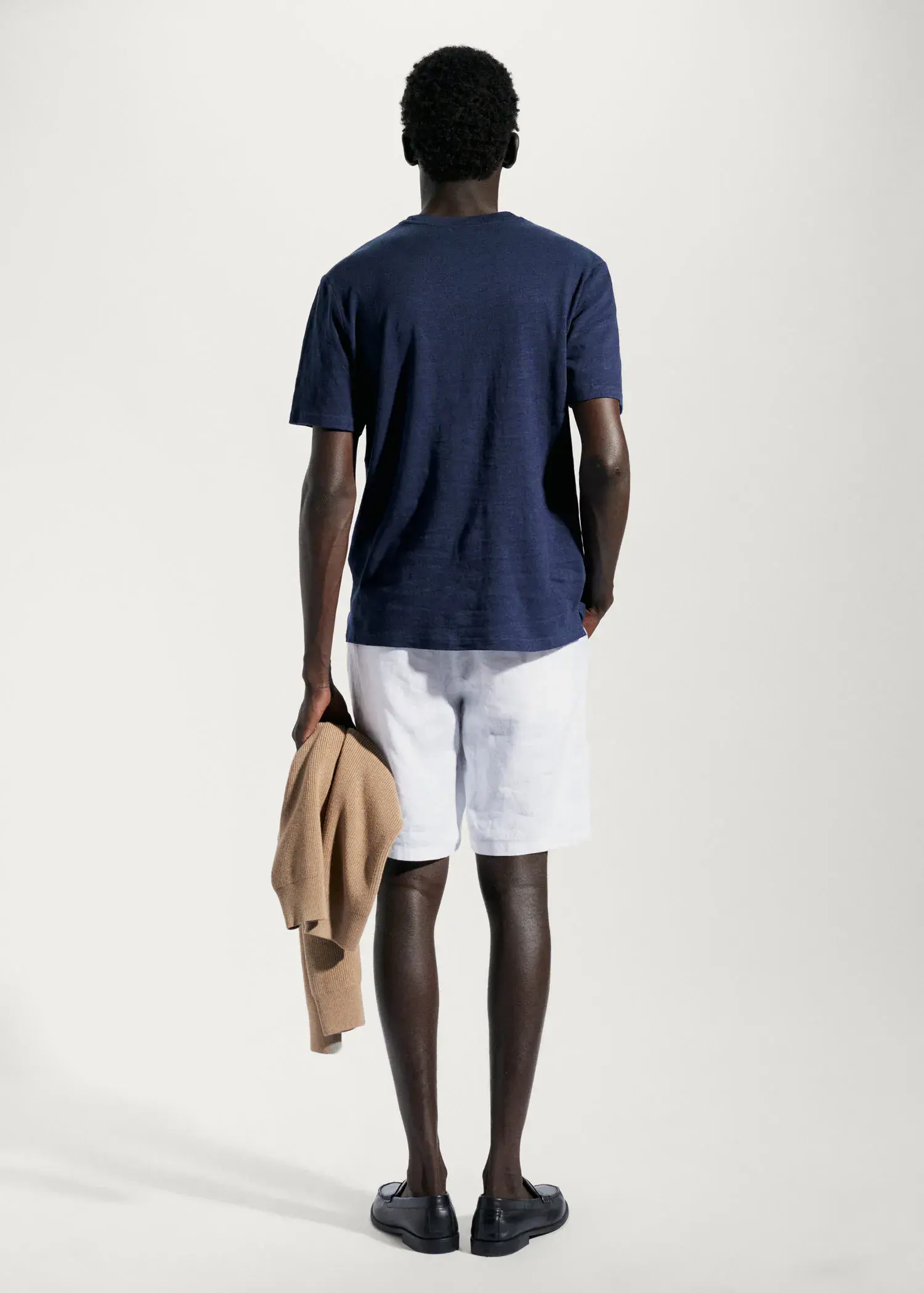 Mango Cotton-linen pocket t-shirt. a man in shorts and a t-shirt is holding a jacket. 