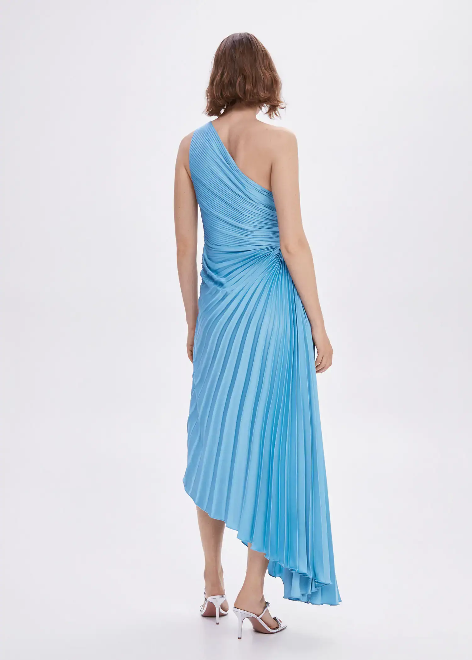 Mango Asymmetrical pleated dress. a woman wearing a blue dress standing in a room. 