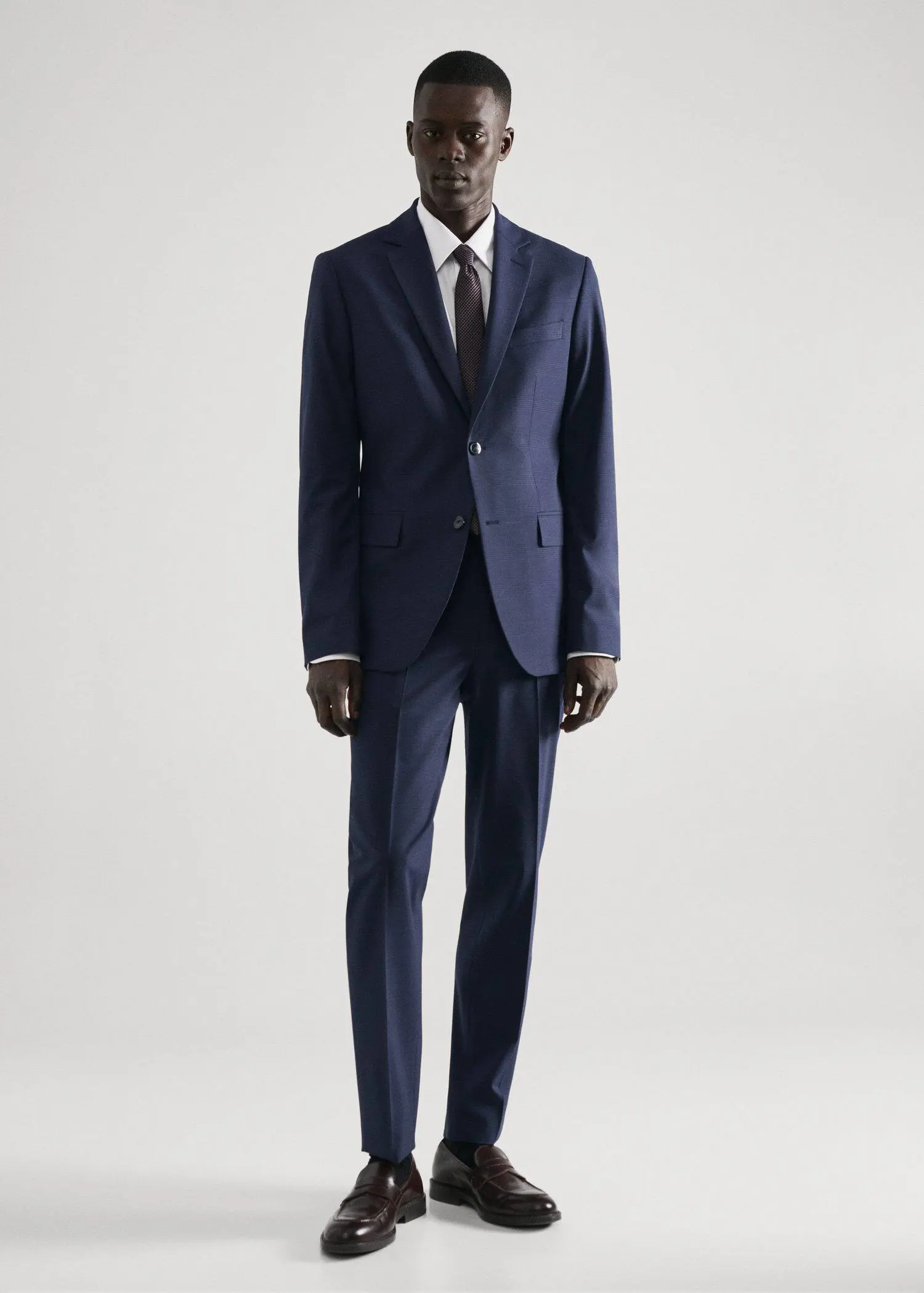 Mango Regular-fit structured suit shirt. a man wearing a suit and tie standing in a room. 