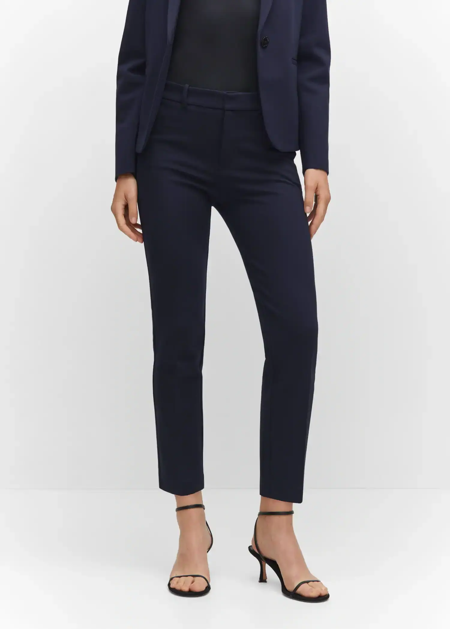 Mango Rome-knit straight trousers. a woman in a black suit and black heels. 