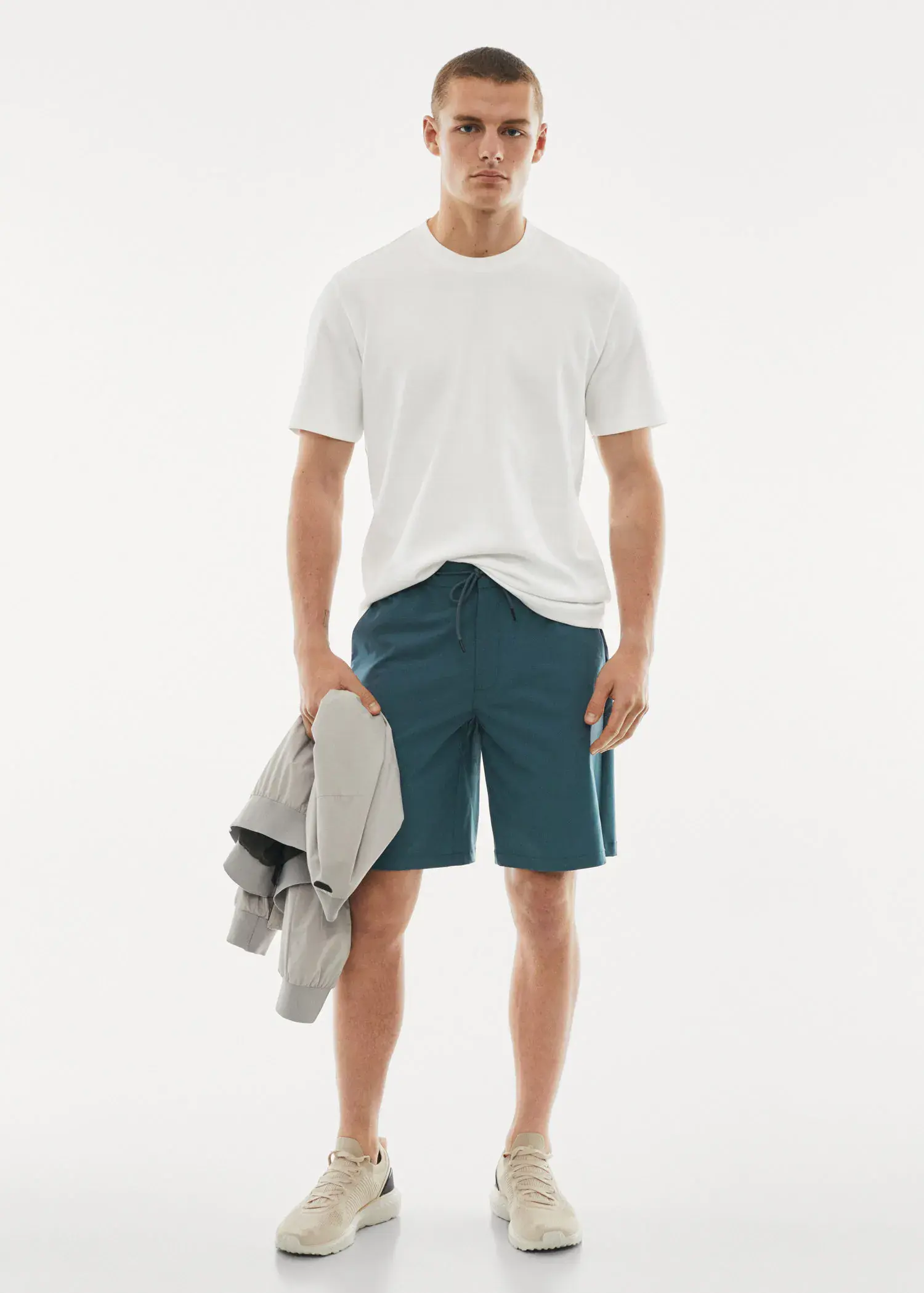 Mango Breathable cotton t-shirt. a young man wearing a white shirt and blue shorts. 