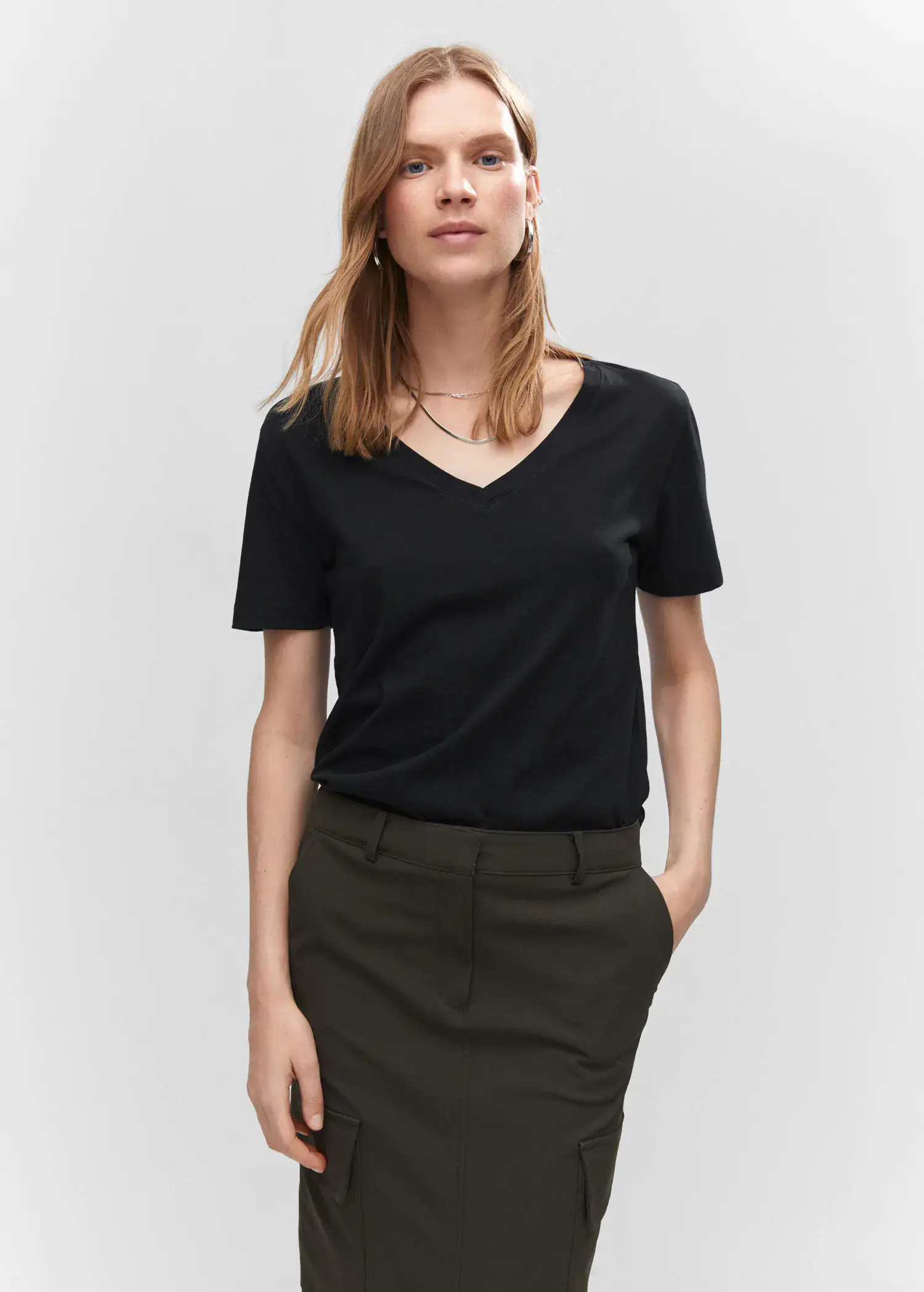 Mango V-neck cotton T-shirt. a woman wearing a black shirt and a brown skirt. 