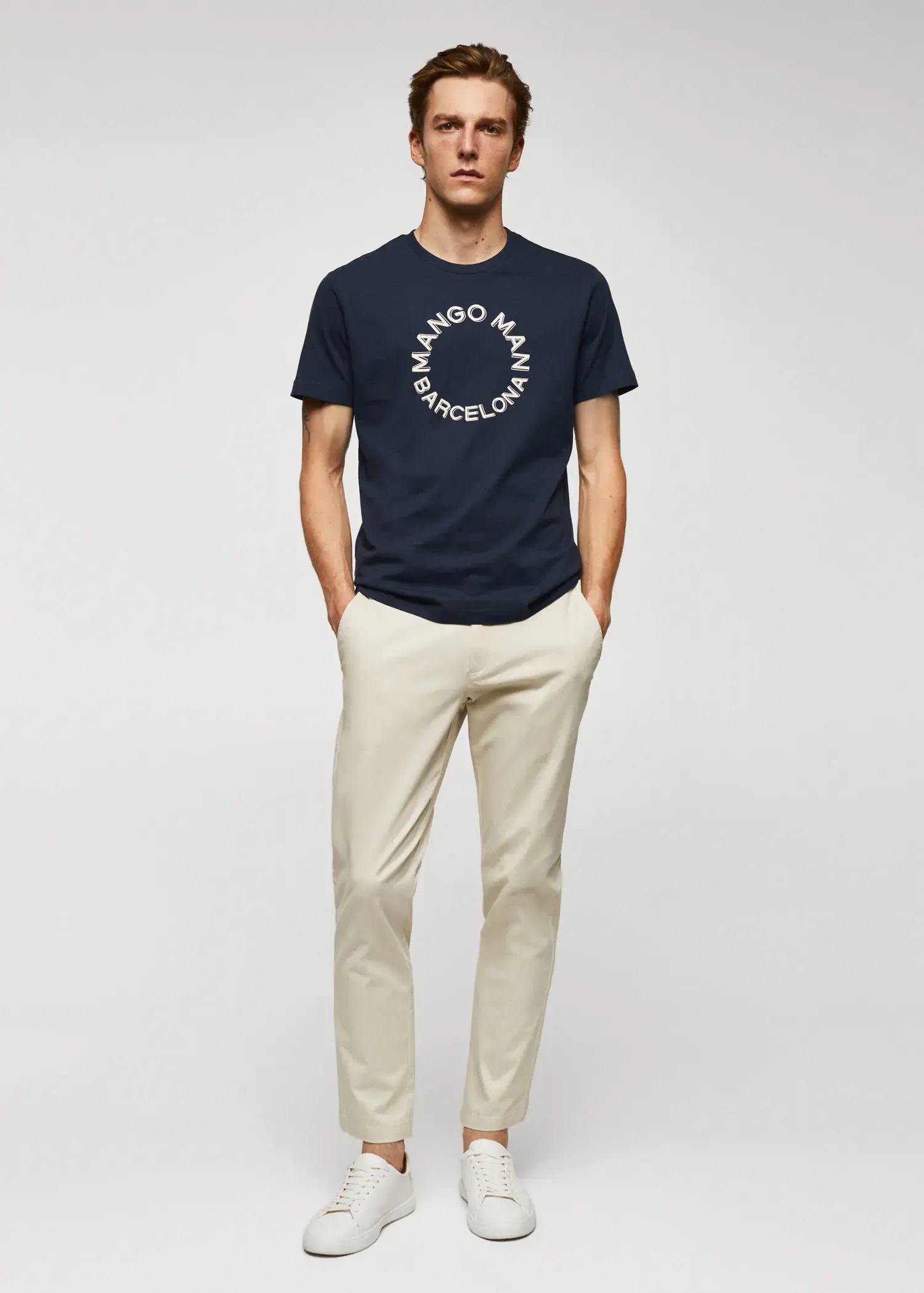 Mango 100% cotton t-shirt with logo. a man in a navy blue t-shirt and beige pants. 