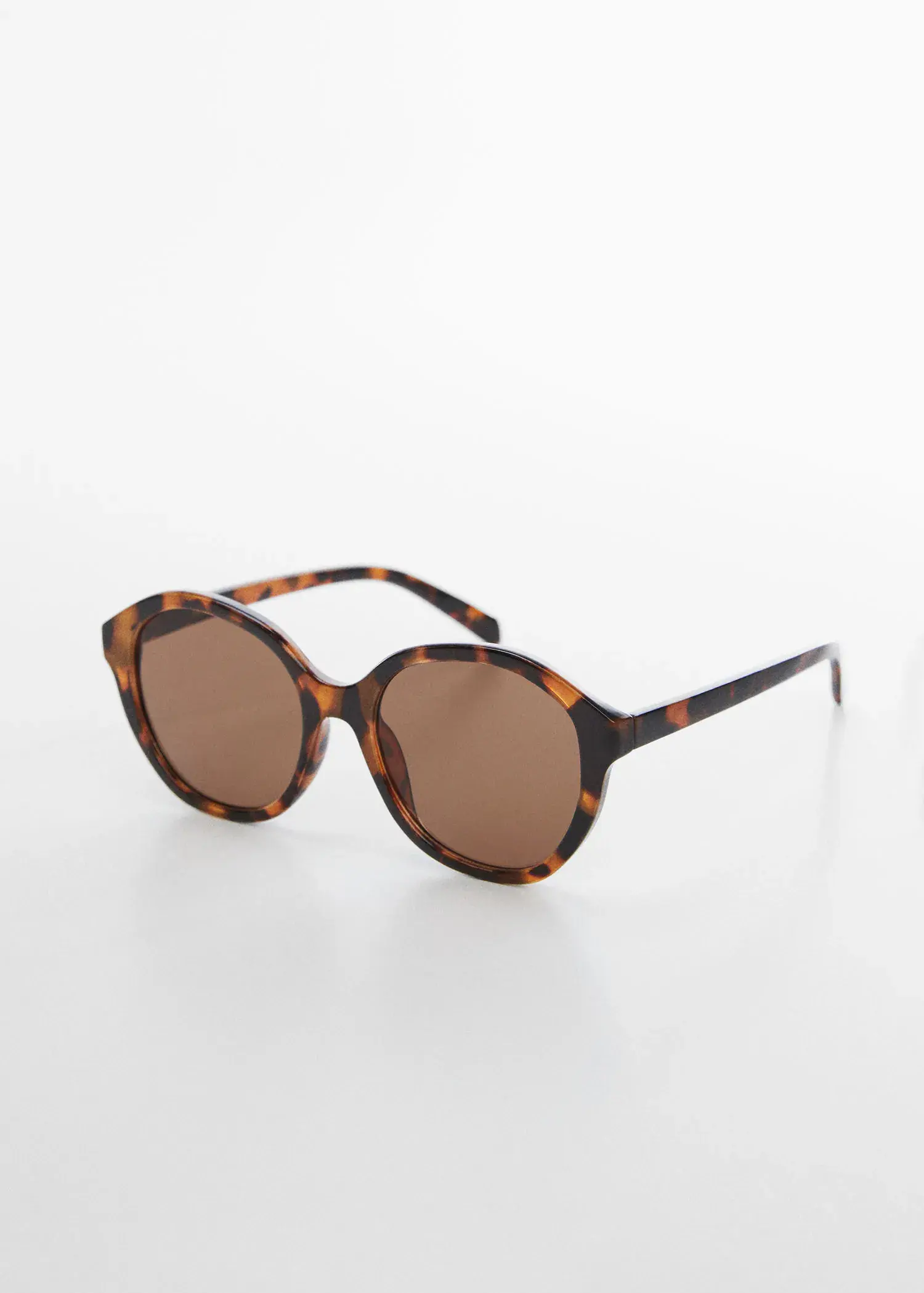 Mango Tortoiseshell rounded sunglasses. a pair of sunglasses sitting on top of a white table. 