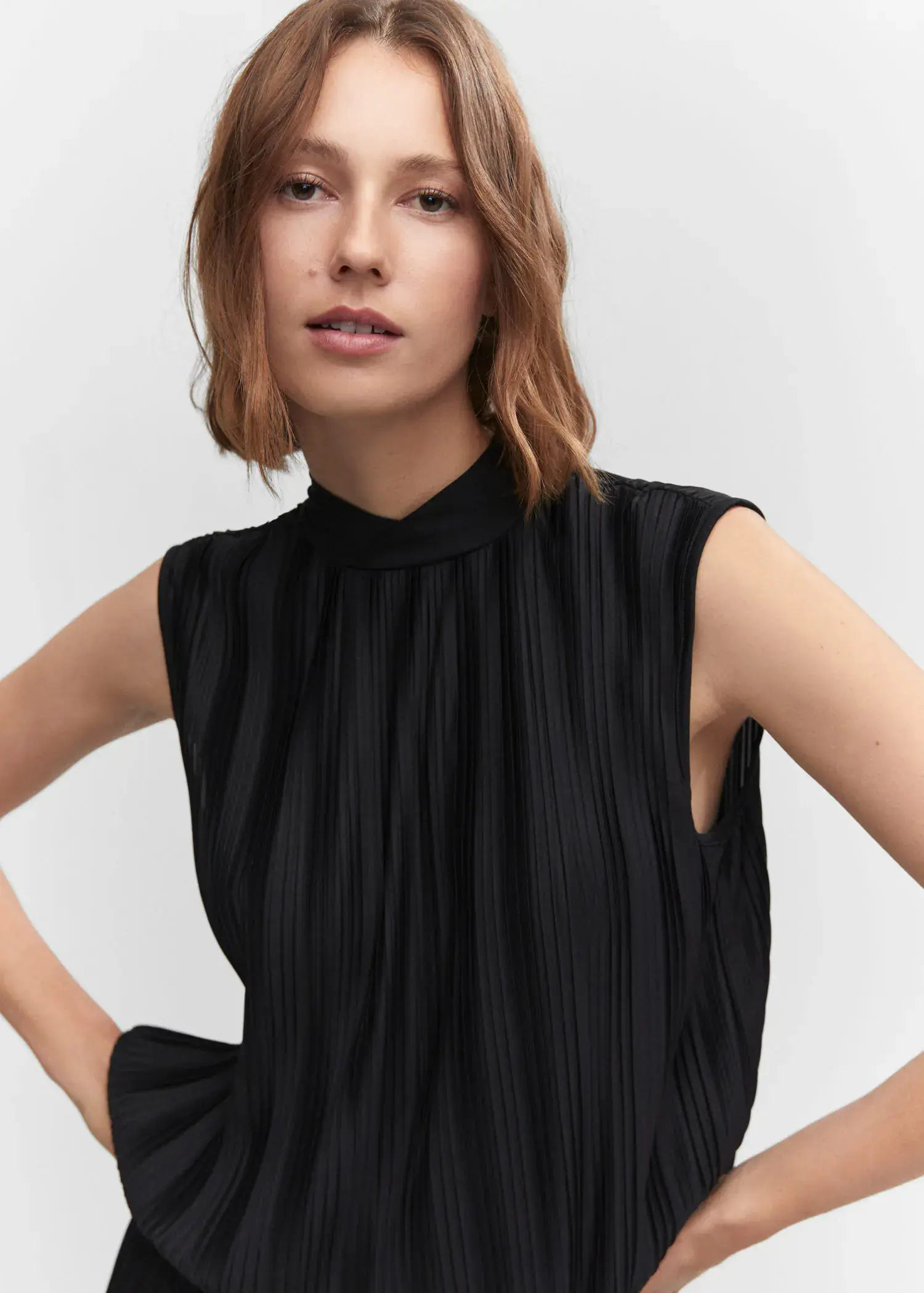 Mango Pleated bow top. a woman wearing a black dress posing for a picture. 