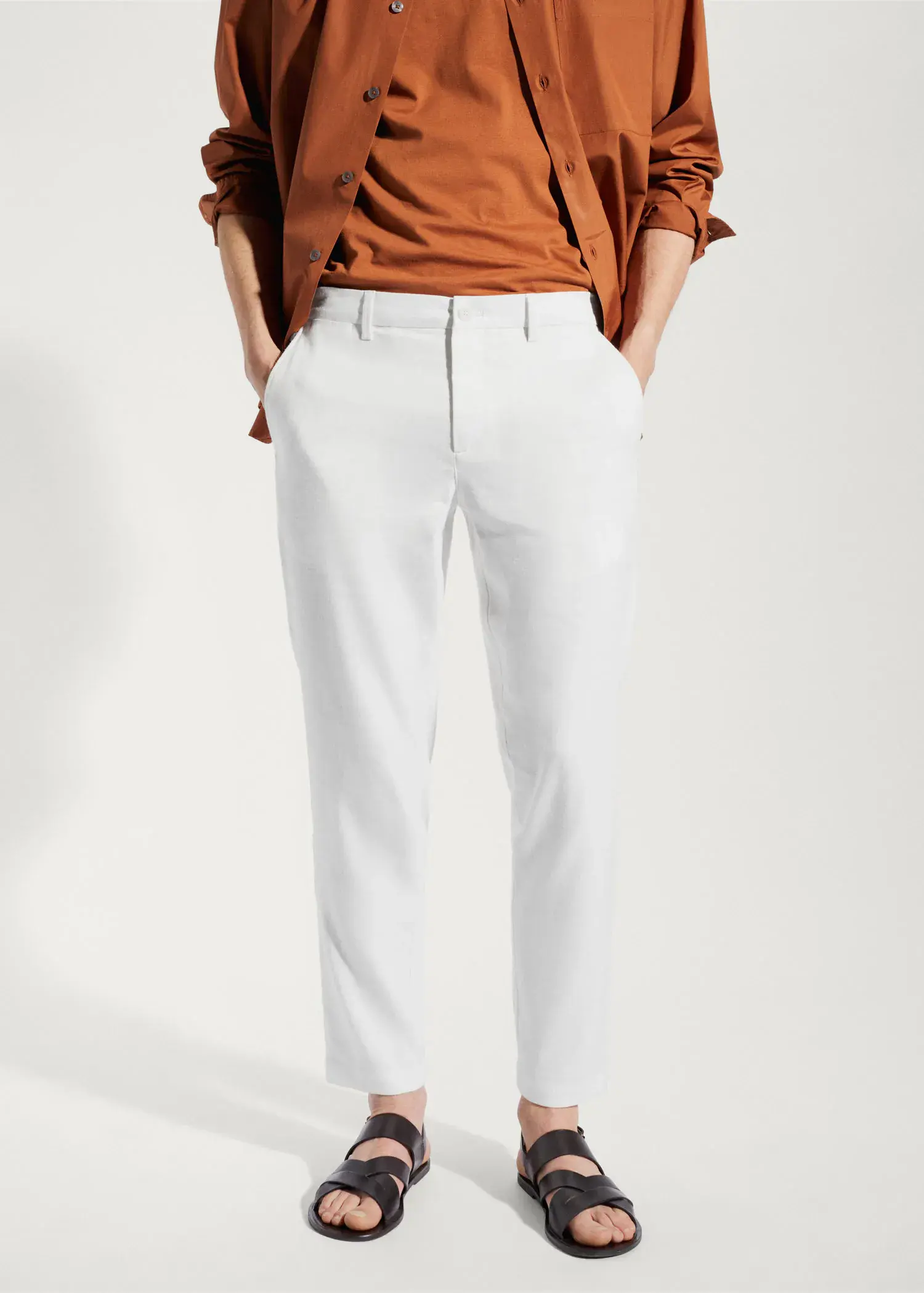 Mango Linen slim-fit trousers with inner drawstring. a person standing in front of a white wall. 