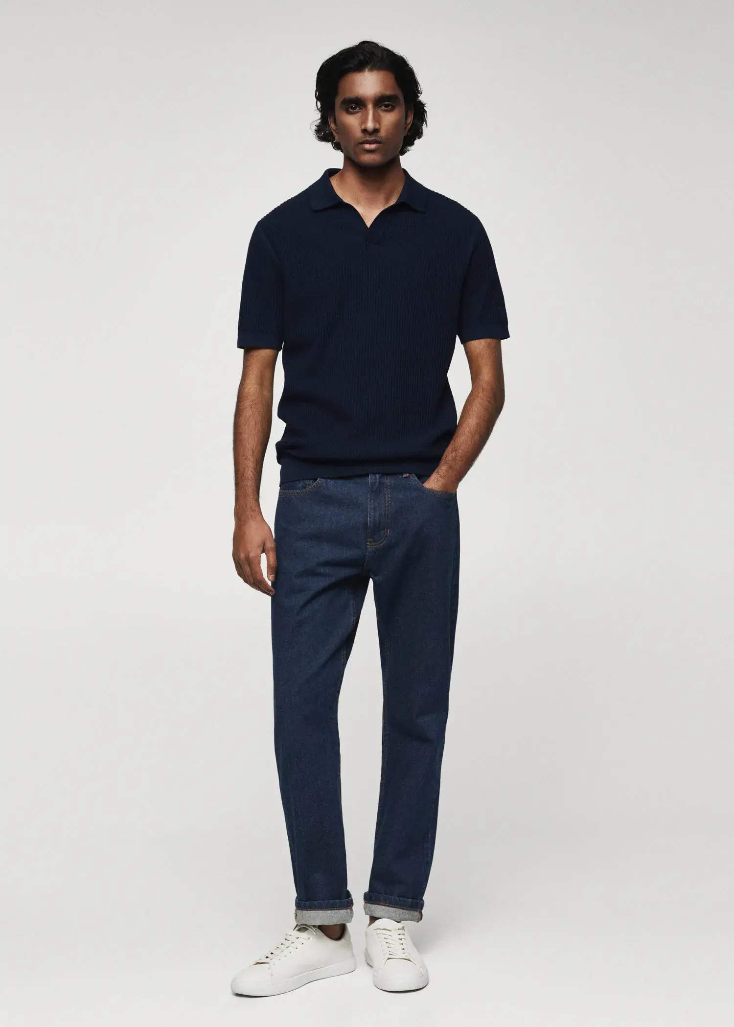 Mango Ribbed cotton polo shirt. a man in a black shirt and blue pants. 
