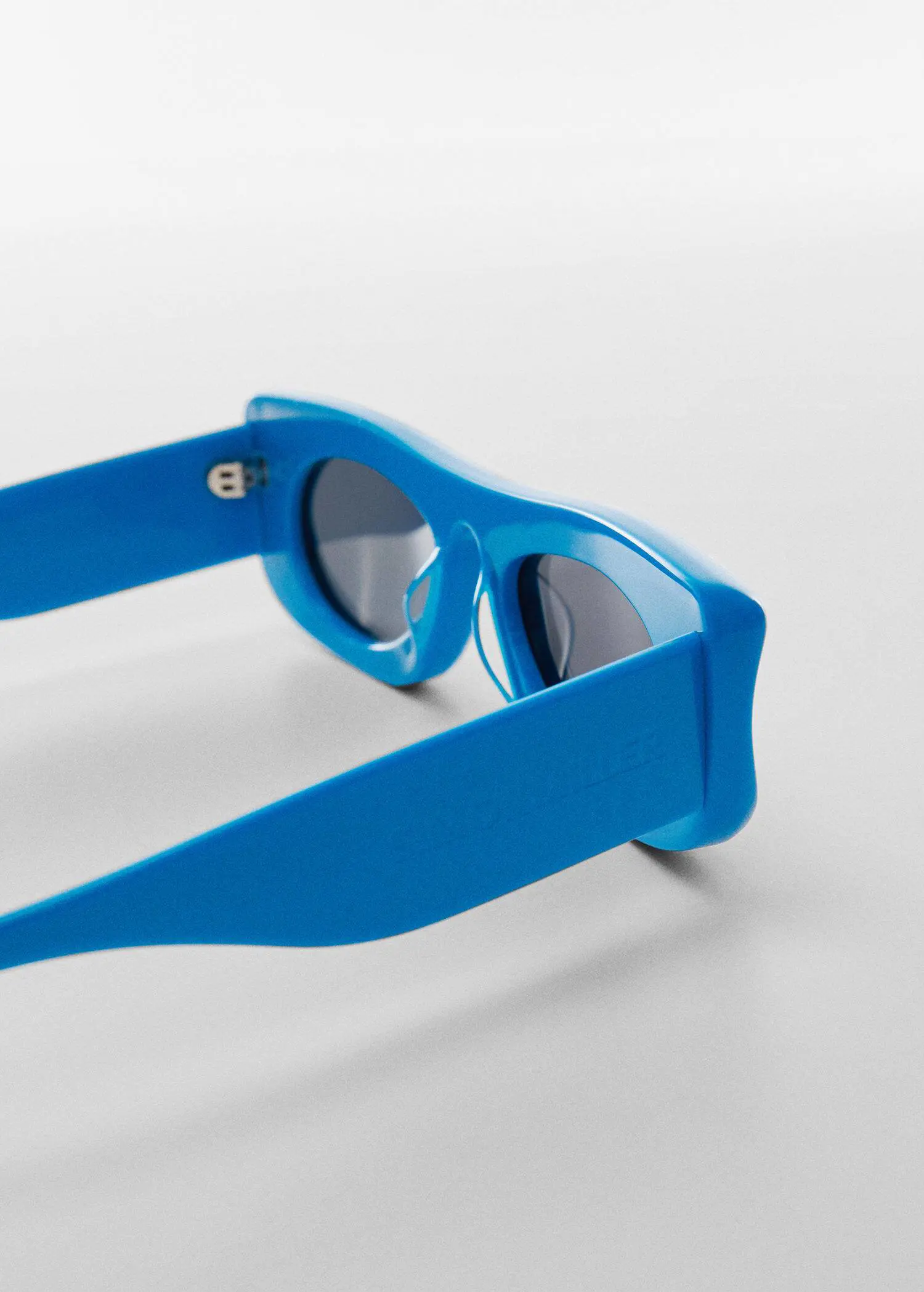 Mango Volume frame sunglasses. a pair of blue sunglasses sitting on top of a table. 
