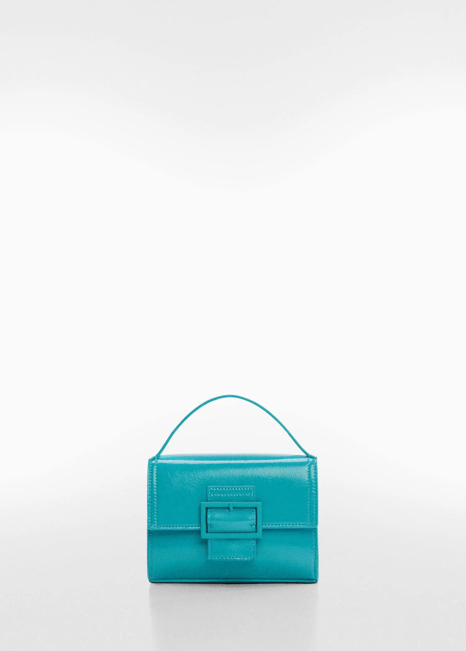 Mango Buckled flap bag. a blue purse is sitting on a table. 
