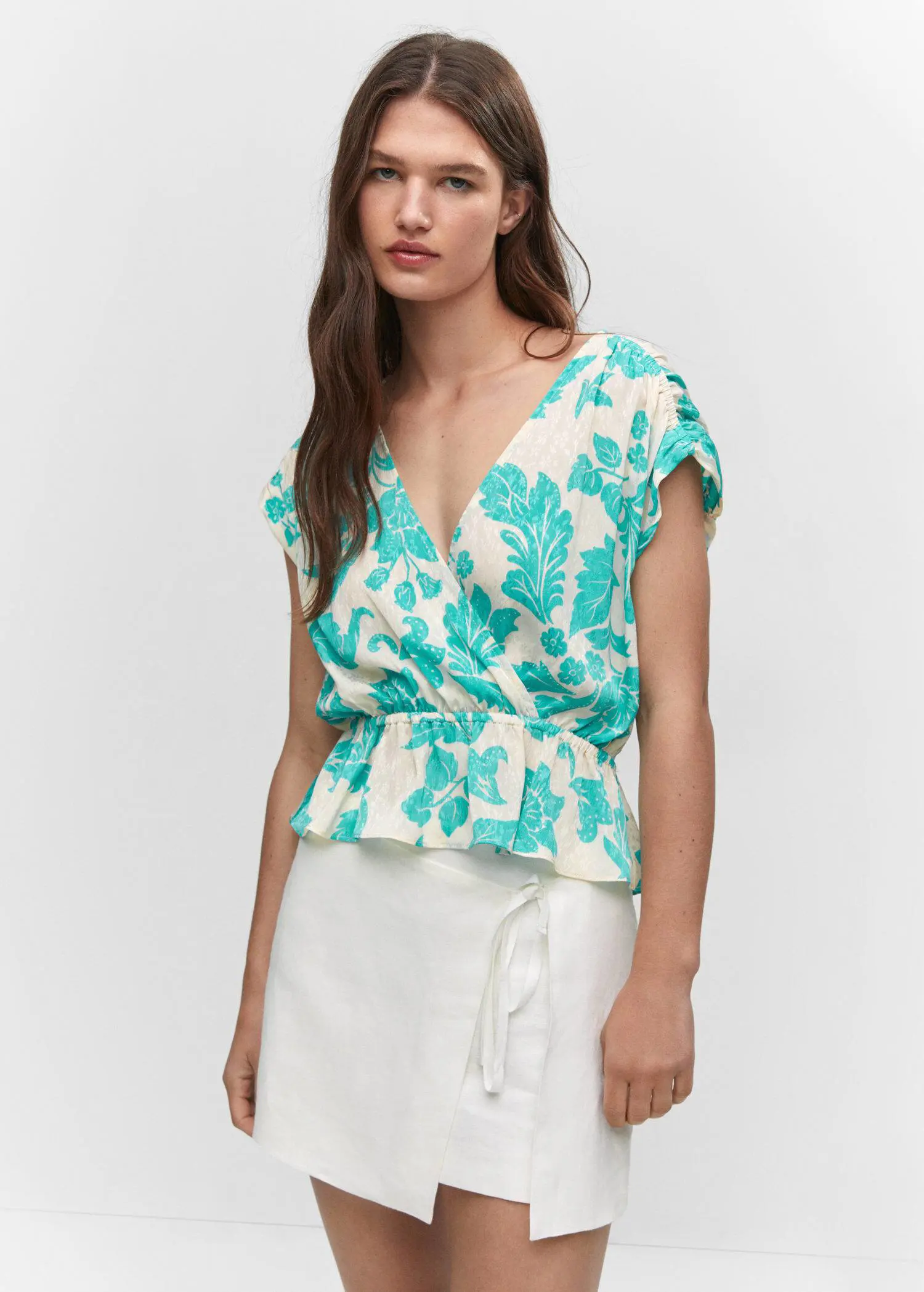 Mango Wrap floral blouse. a woman wearing a white skirt and a blue top. 