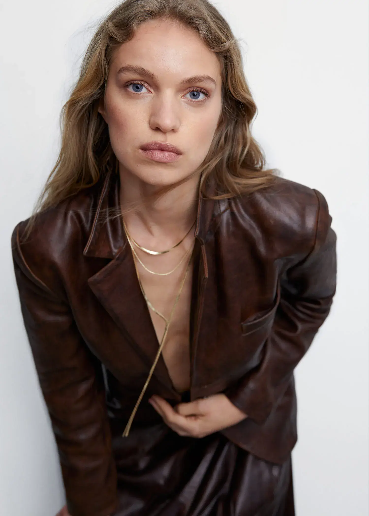 Mango Long triple necklace. a woman wearing a brown leather jacket and a necklace. 