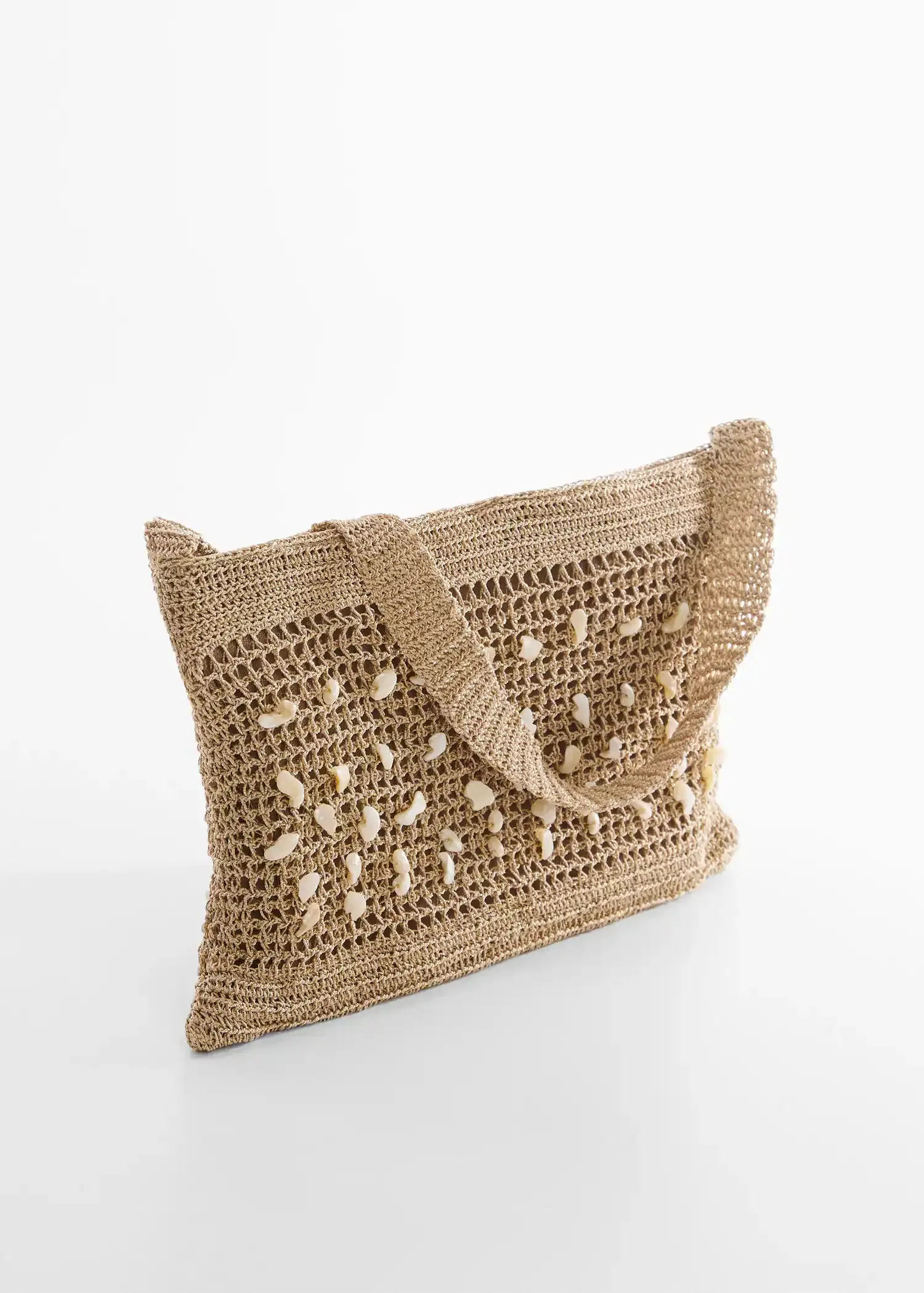 Mango Crochet bag with shell detail. a crocheted bag is shown on a table. 