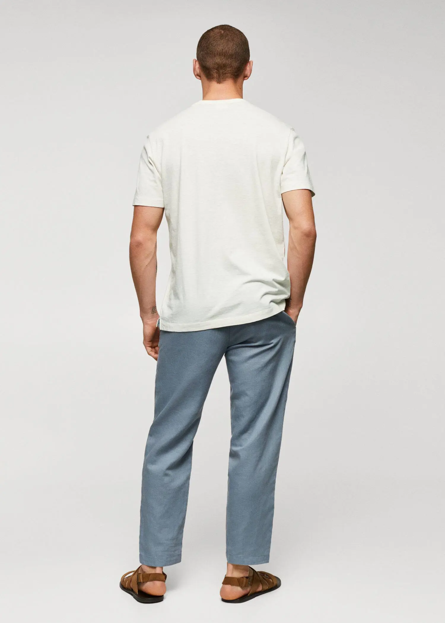 Mango 100% cotton t-shirt with pocket. a man standing with his hands in his pockets. 