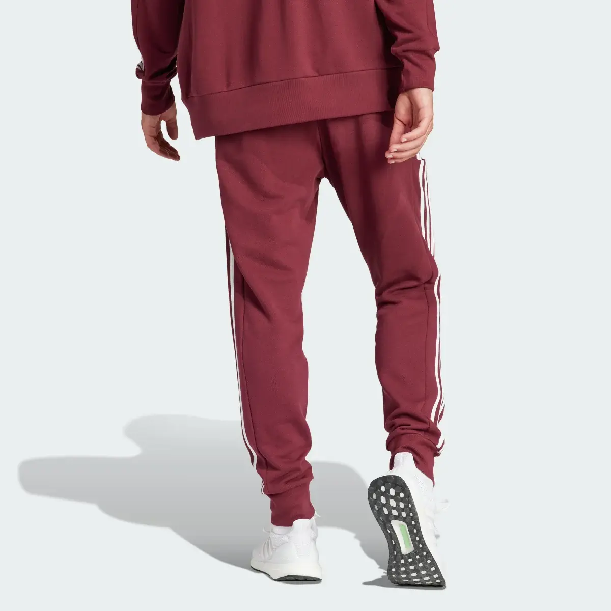 Adidas Pantaloni Essentials French Terry Tapered Cuff 3-Stripes. 2