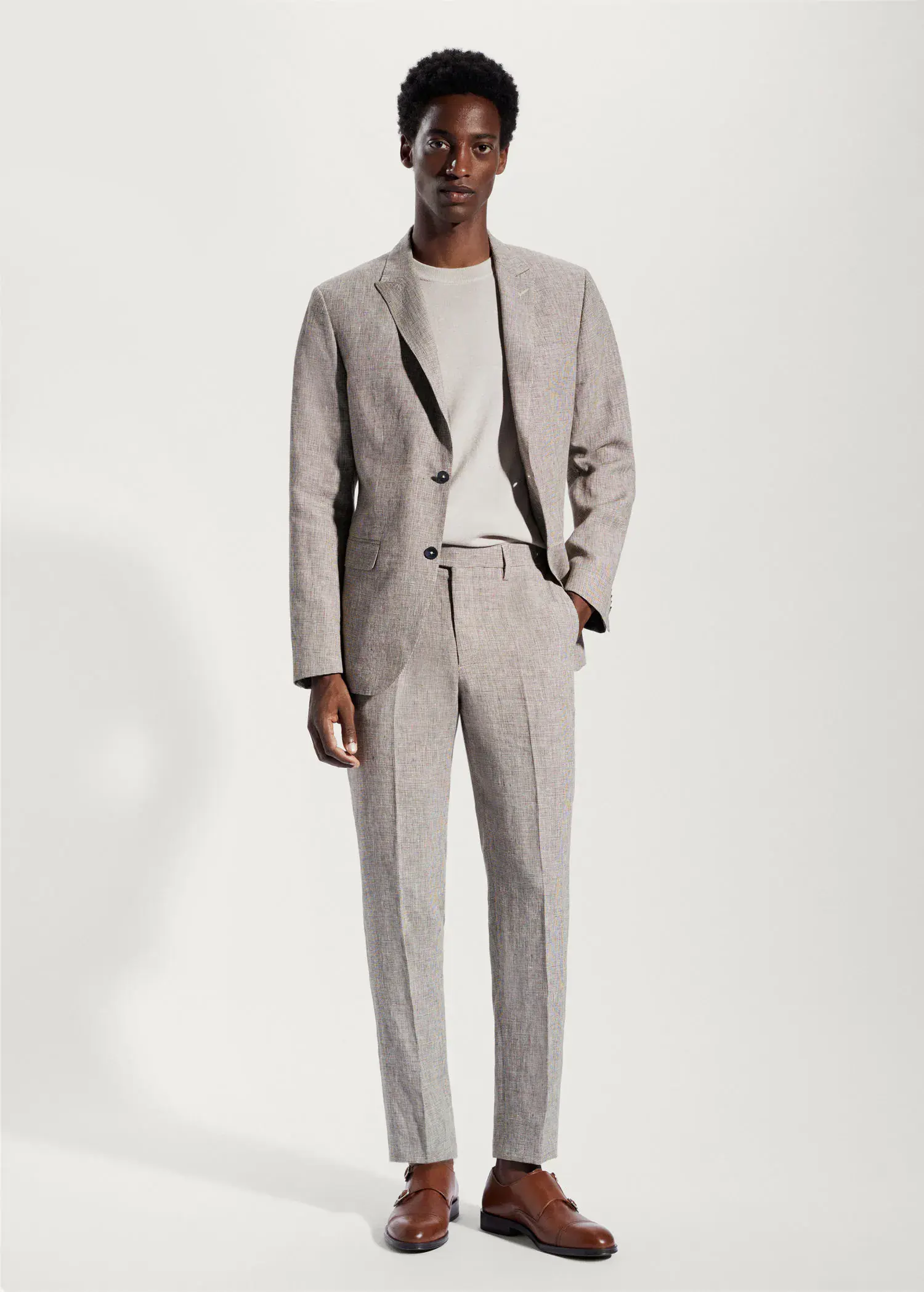 Mango 100% linen suit trousers. a man in a suit standing in front of a white wall. 