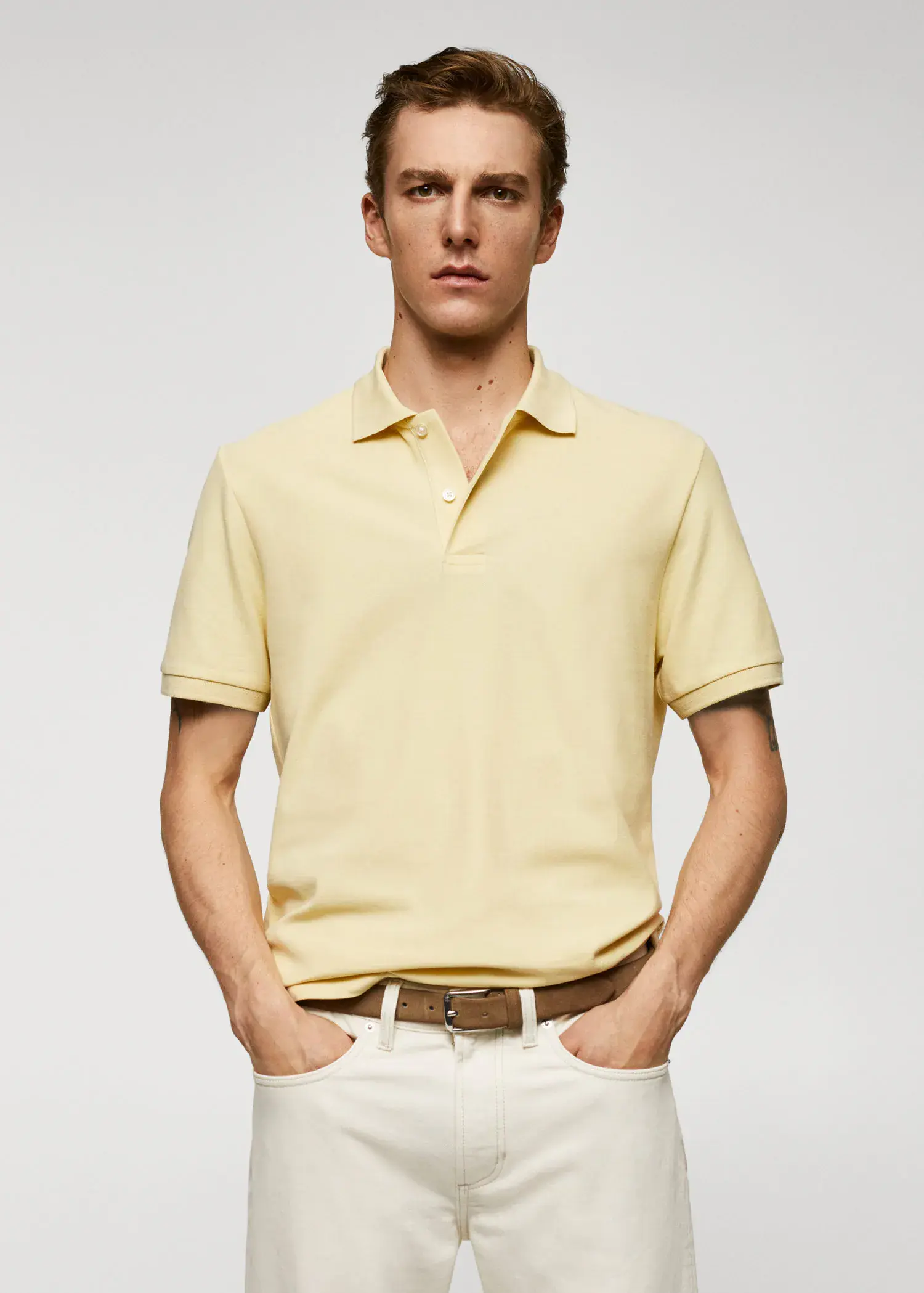 Mango 100% cotton pique polo shirt. a man in a yellow polo shirt and white pants. 