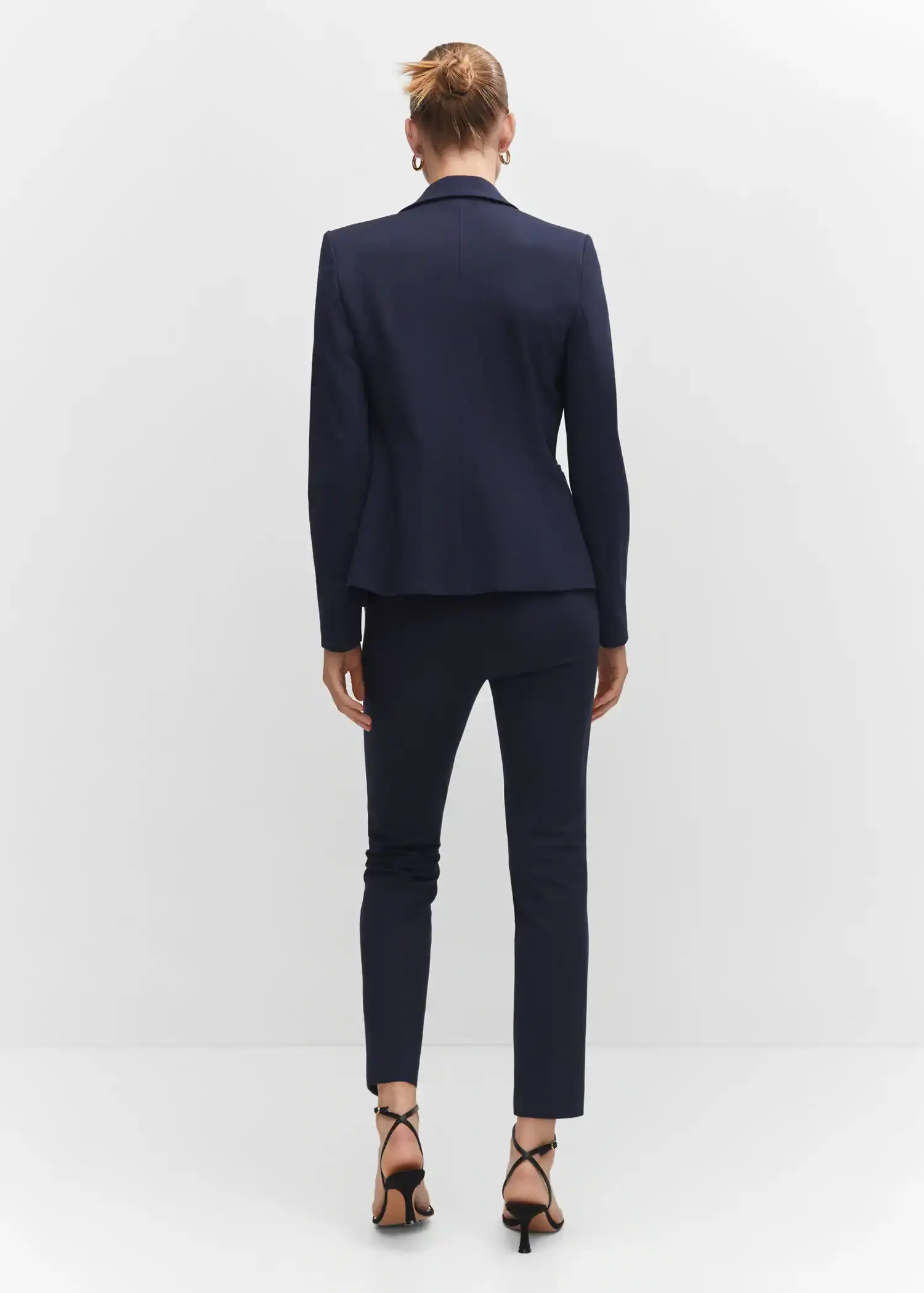 Mango Rome-knit straight trousers. a woman wearing a suit standing in front of a white wall. 