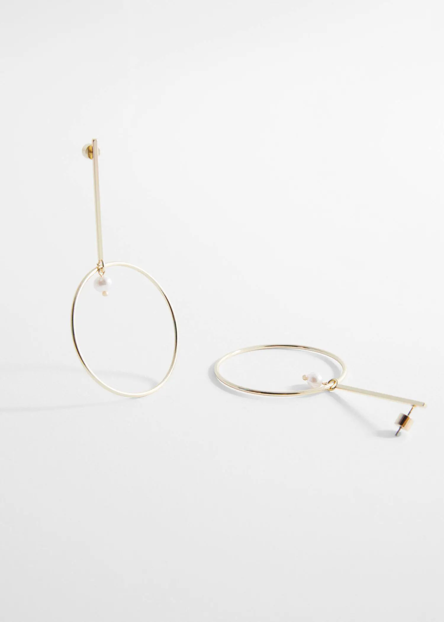 Mango Thread hoop earrings. a pair of earrings sitting on top of a white table. 