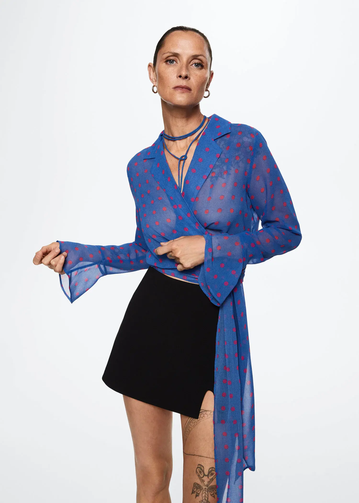 Mango Sheer polka-dot blouse. a woman in a blue shirt and black skirt. 