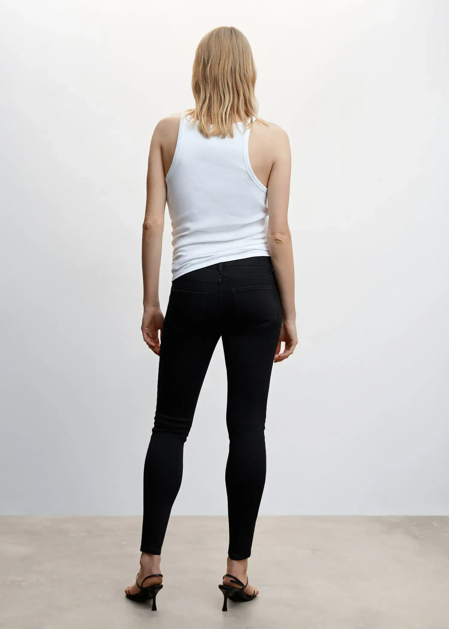 Mango Maternity skinny jeans. a woman in black pants and a white shirt. 
